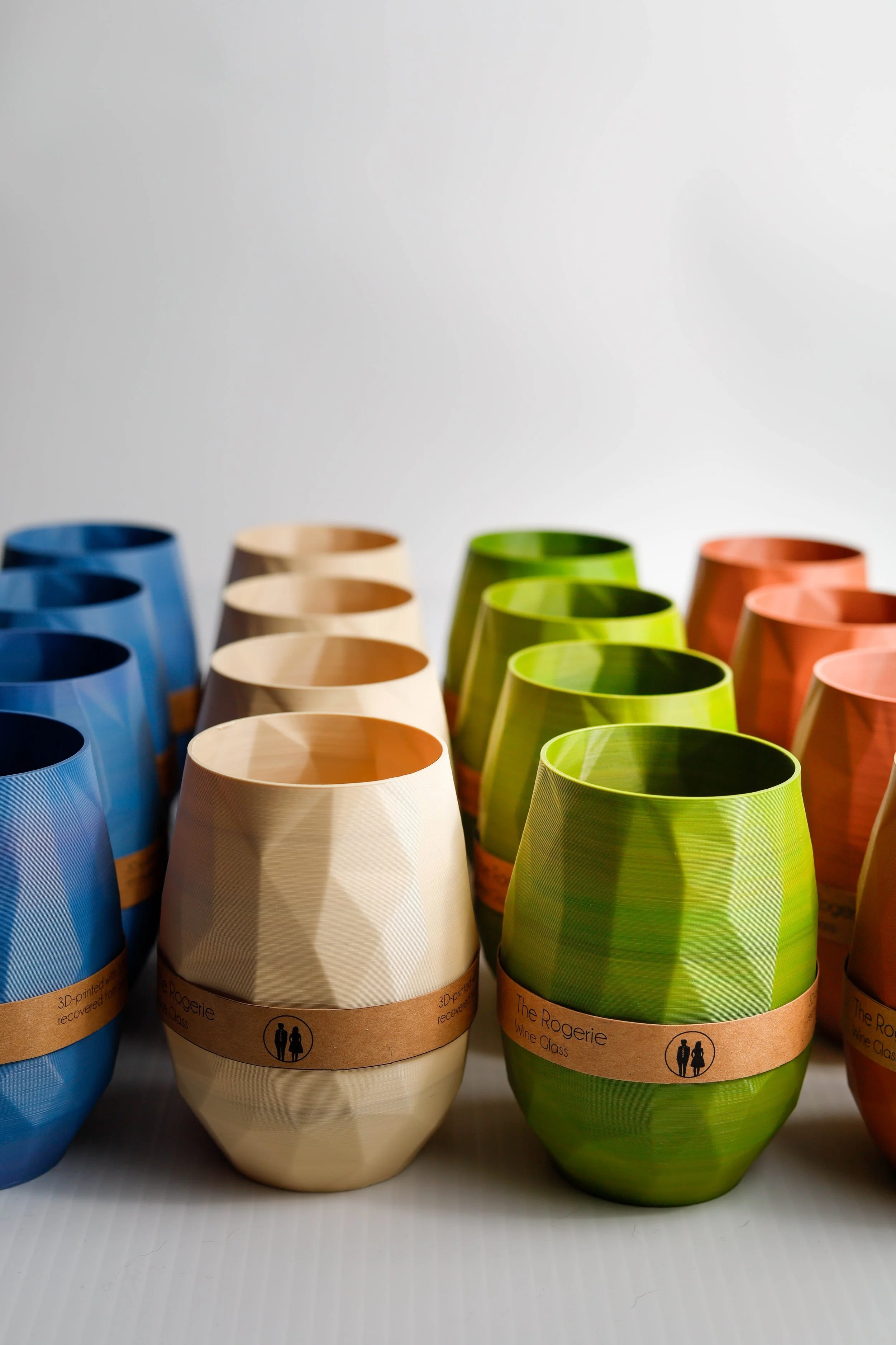 High-quality commercial product photography of colorful, 3D-printed geometric wine cups by The Rogerie, captured in a clean studio setting in Calgary
