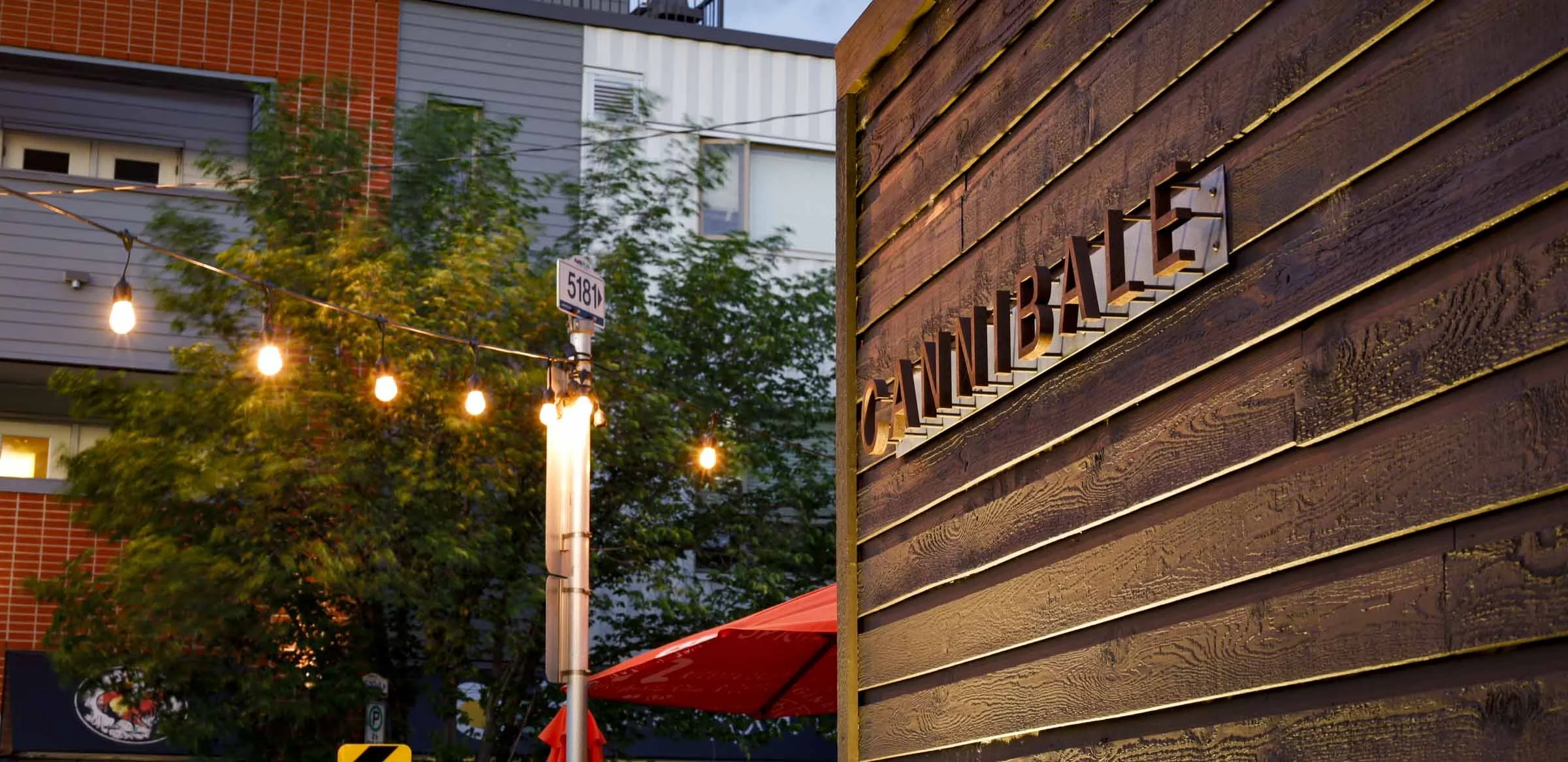 Strategic outdoor lighting and architectural signage for Cannibale in Bridgeland, showcasing district vibrancy at dusk