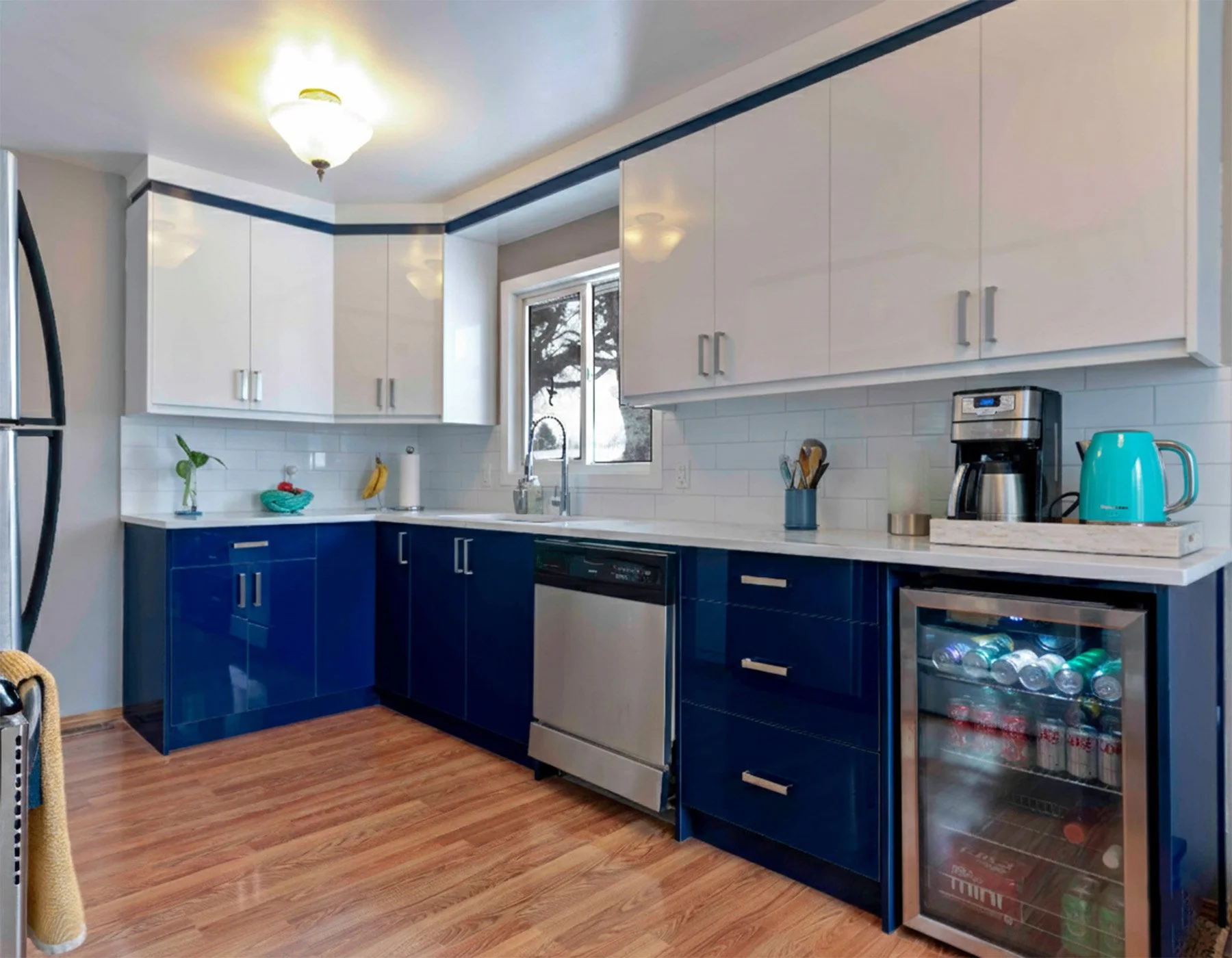 Professional real estate photography of a remodeled kitchen with blue and white glossy cabinets by Shifting Focus Photography