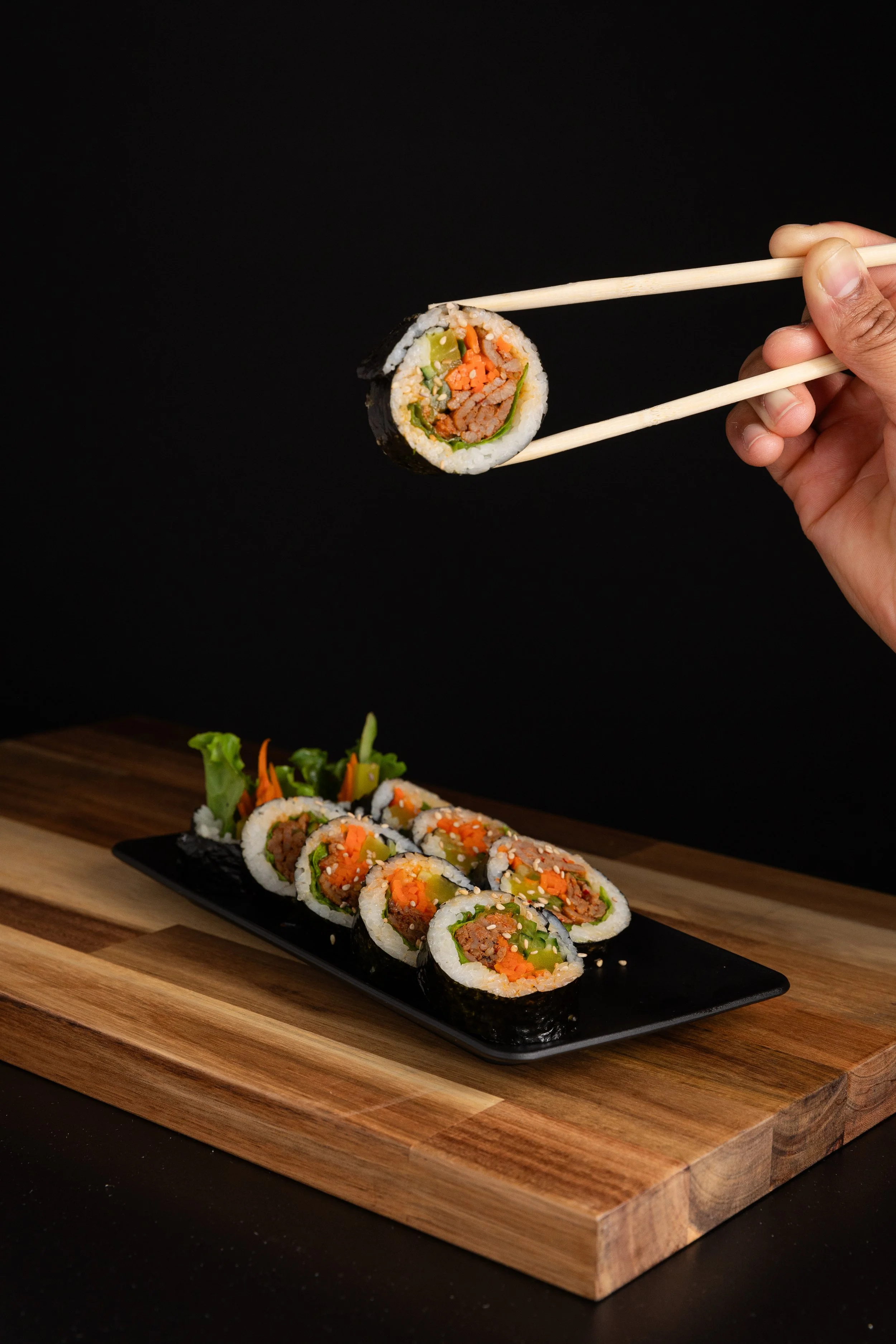 Kimbap Spicy Pork Hand Holding Black Background.jpg