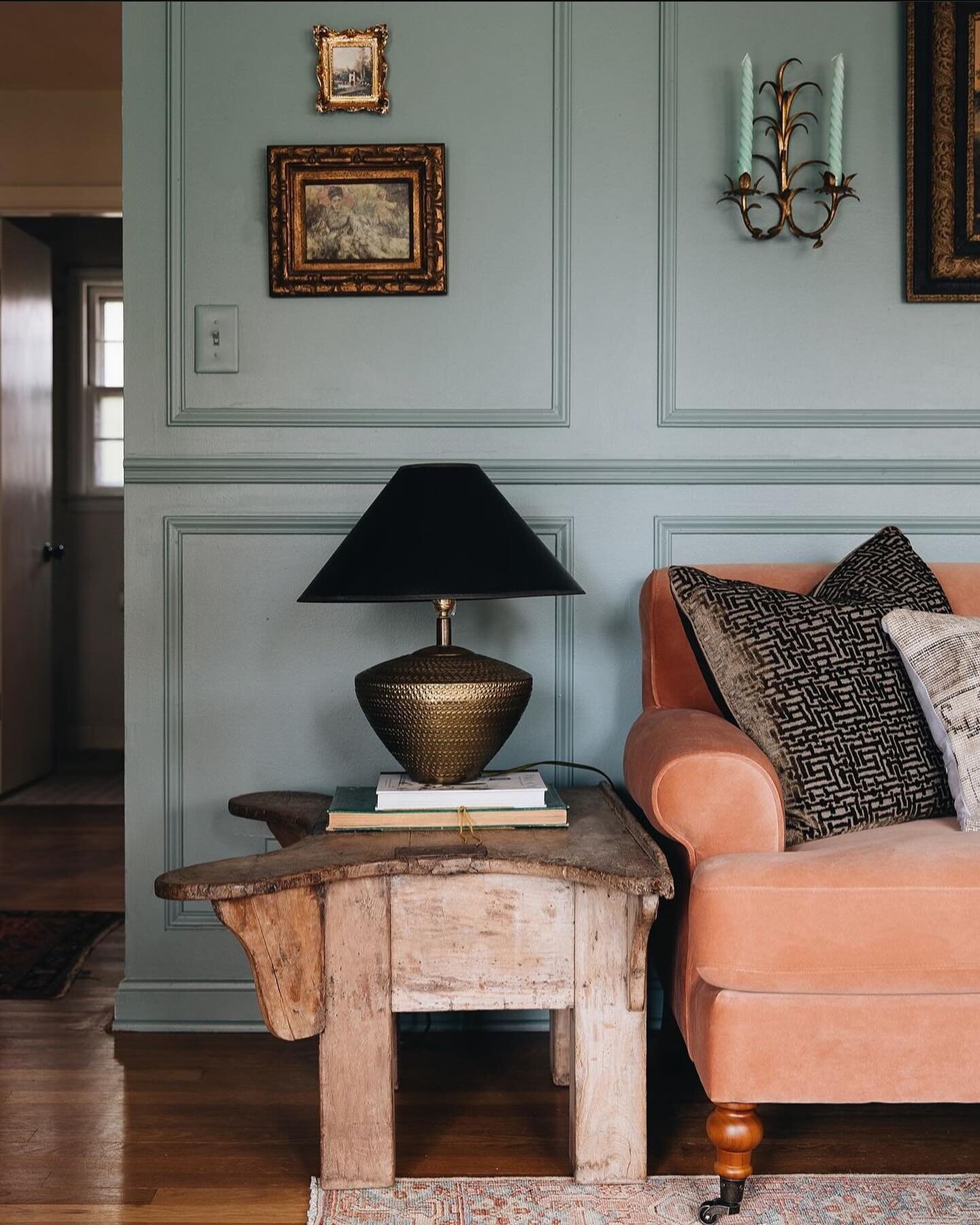 INSPIRATION ✨ This beautiful living room by @krosedesigns showcases one of our favorite color combos! The oh so pretty shade of blue paired with an apricot sofa, in velvet no less, is simply heaven! The weathered wood side table, great wall decor and