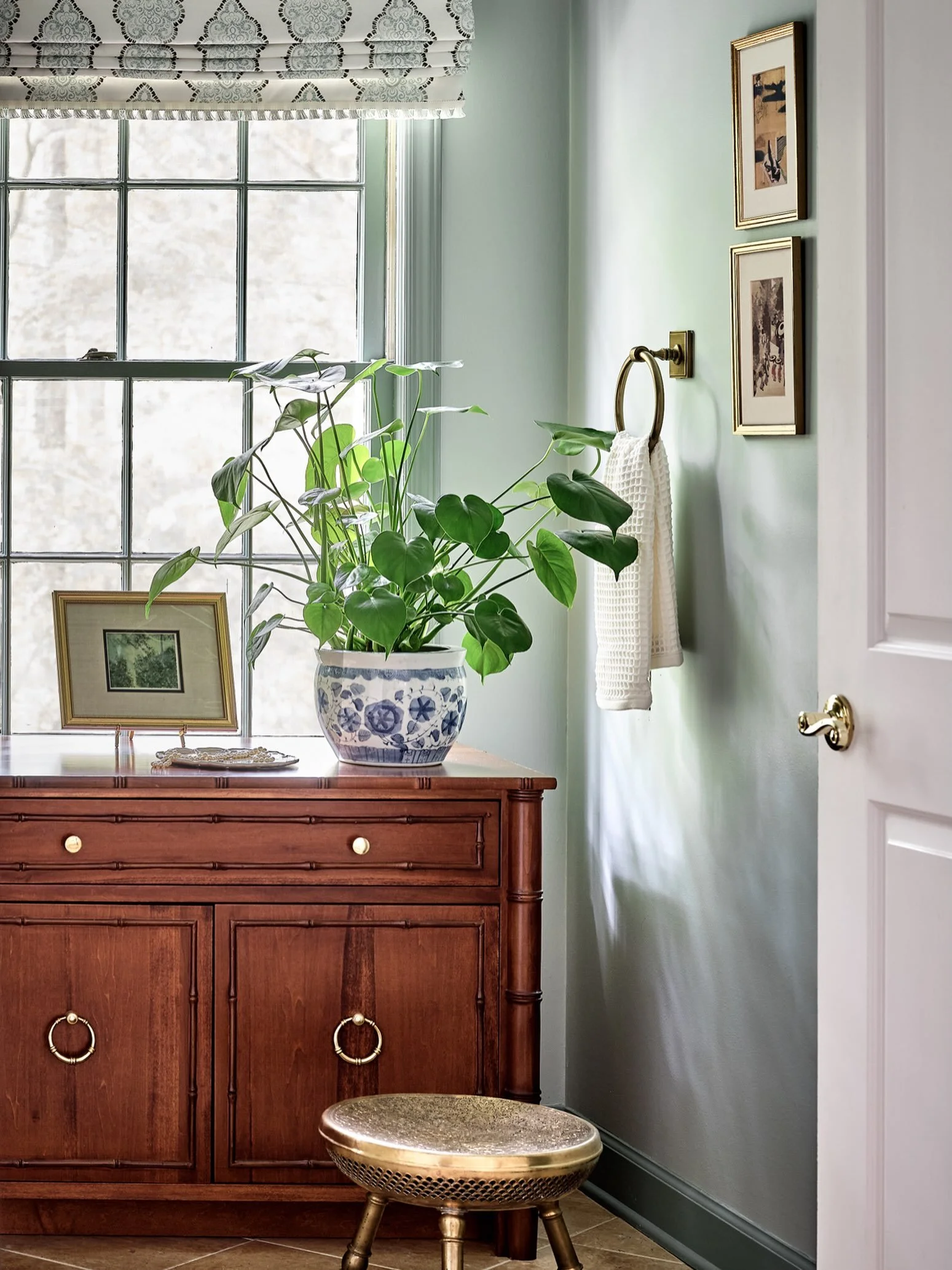 Creating a primary bathroom that feels like a sanctuary starts with the color palette. The soft sage green walls are a perfect complement to the rest of the client&rsquo;s home. We paired it with a darker shade of green trim to create a seamless, env