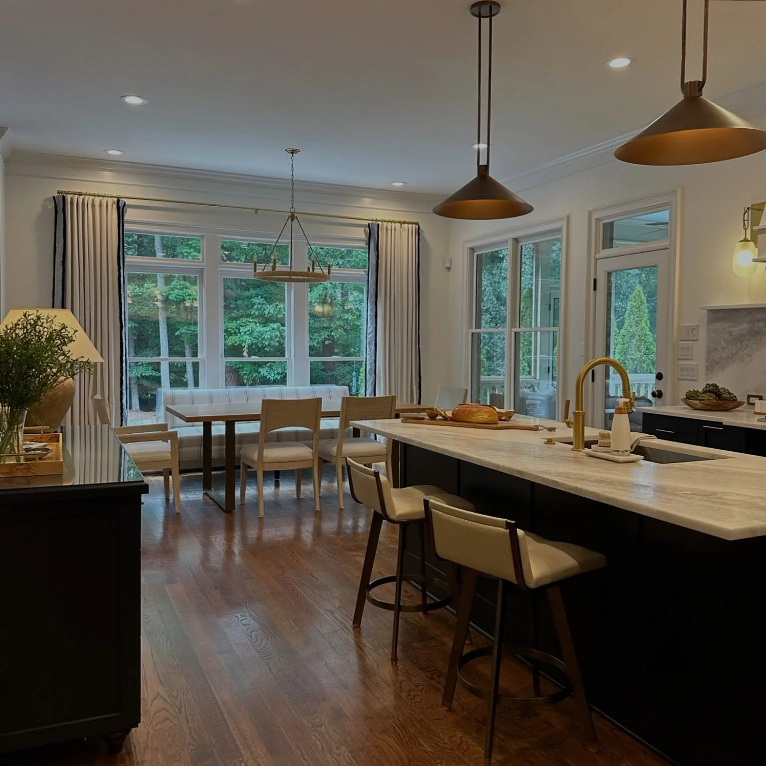 High contrast means high style in this open concept kitchen. Everyday living feels elevated thanks to the rich combination of dark blue cabinetry and marble countertops. The adjoining dining nook is equally inviting for both morning coffee and evenin