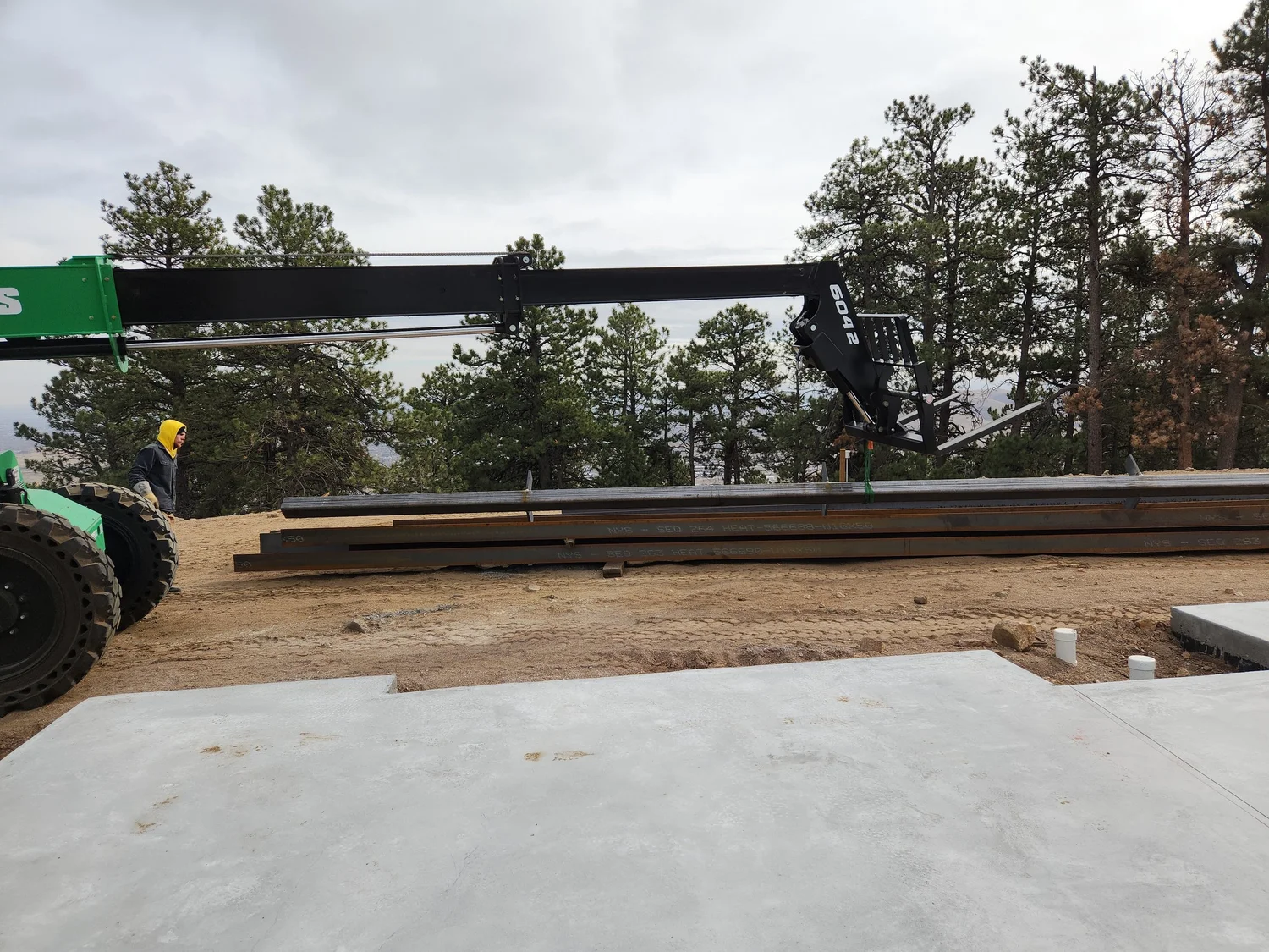 Steel beam being lifted over a concrete slab