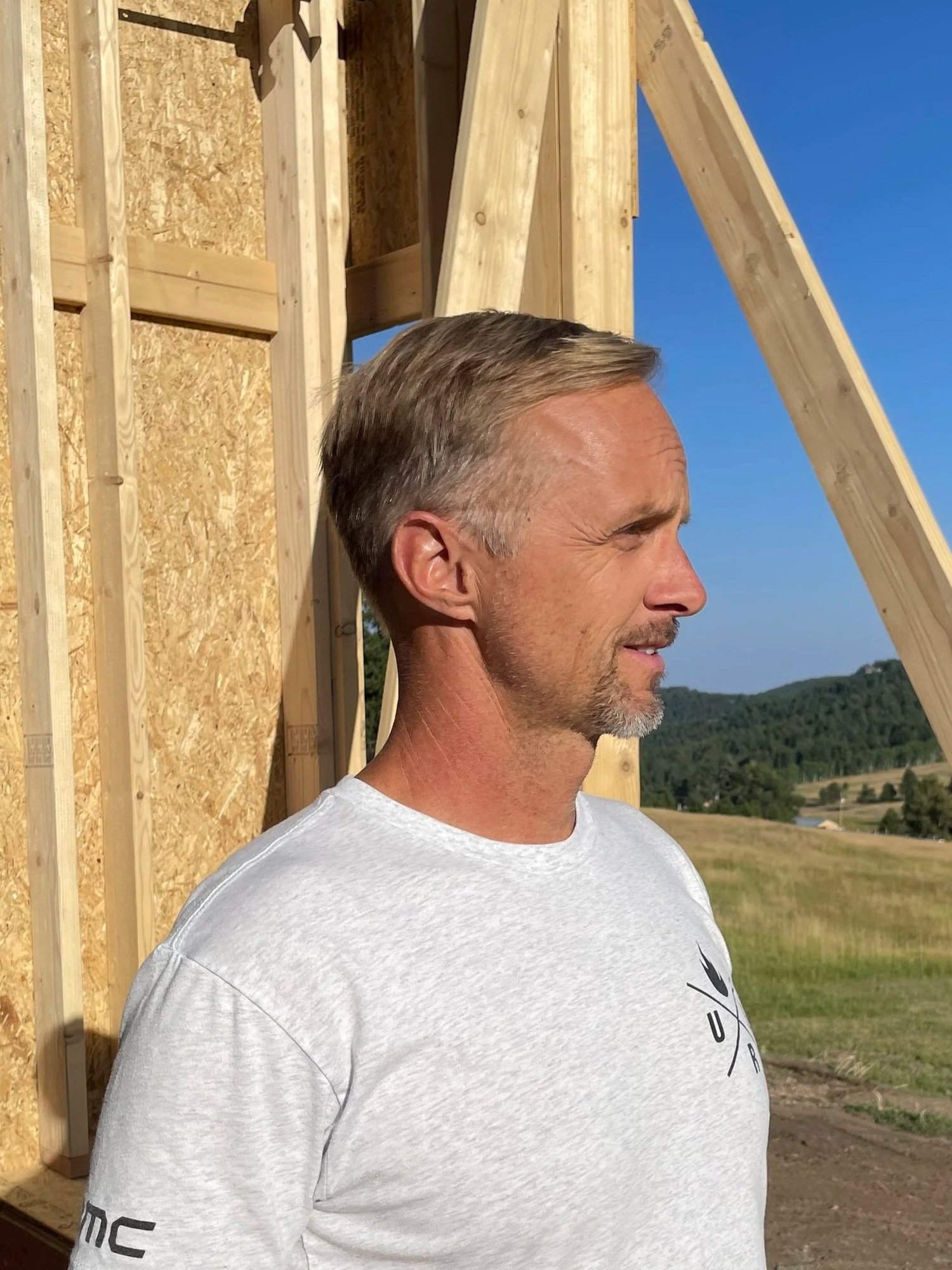 Wade Wheeler on a jobsite in front of new framing