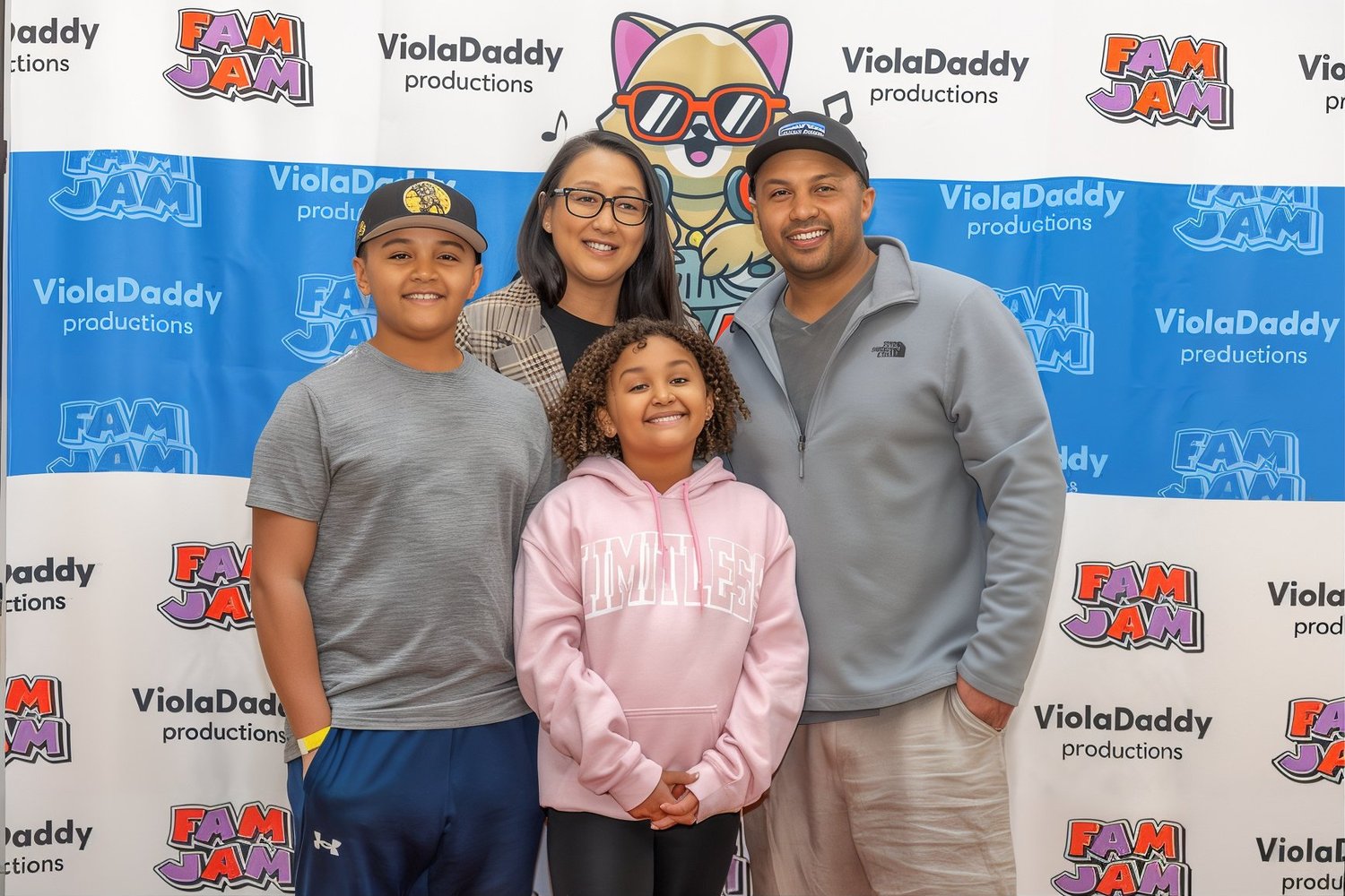 A family smiling in front of the Fam Jam backdrop