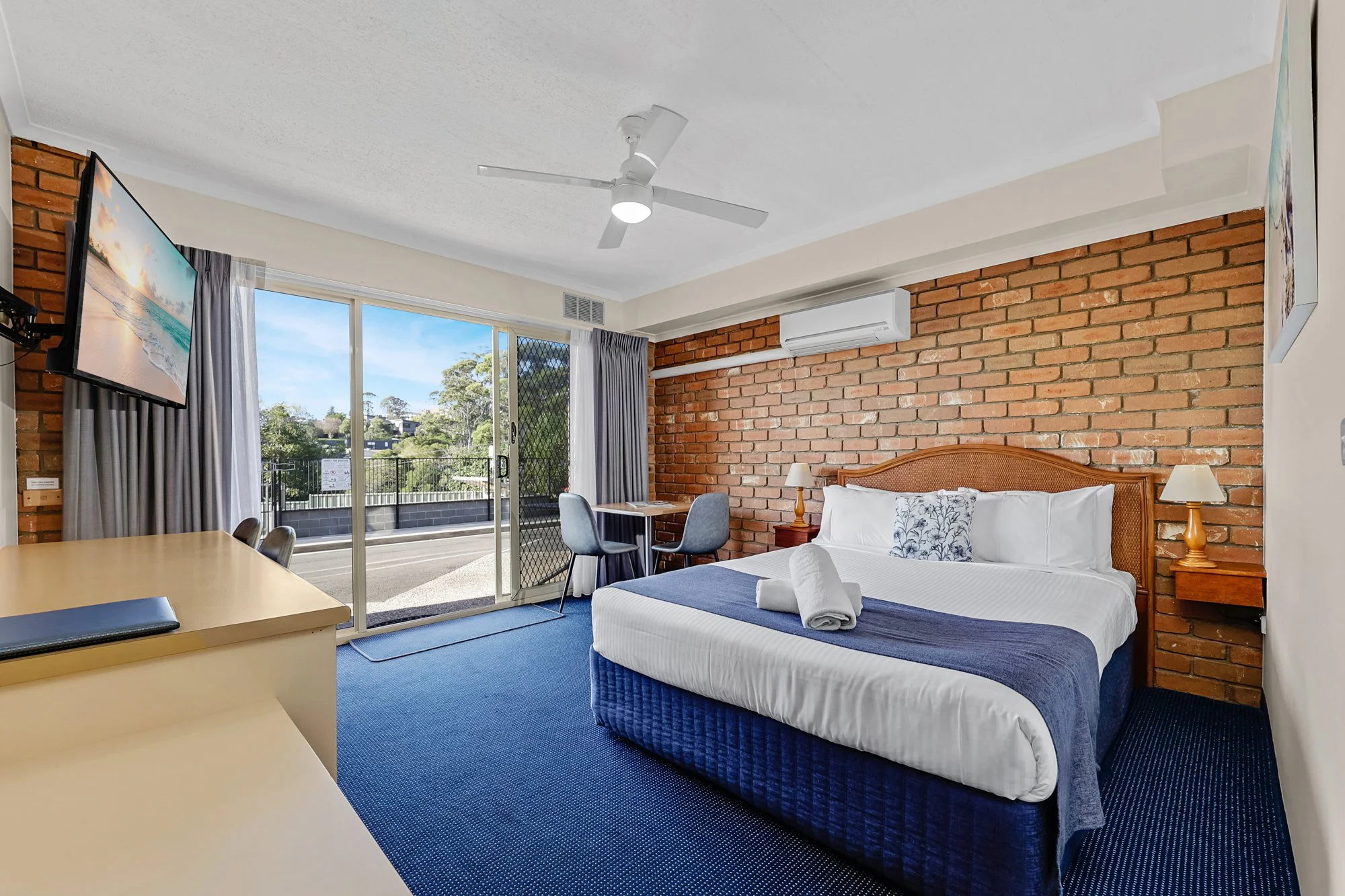 Hotel Photography. Spacious hotel suite bedroom with king bed, modern finishes, and balcony view.