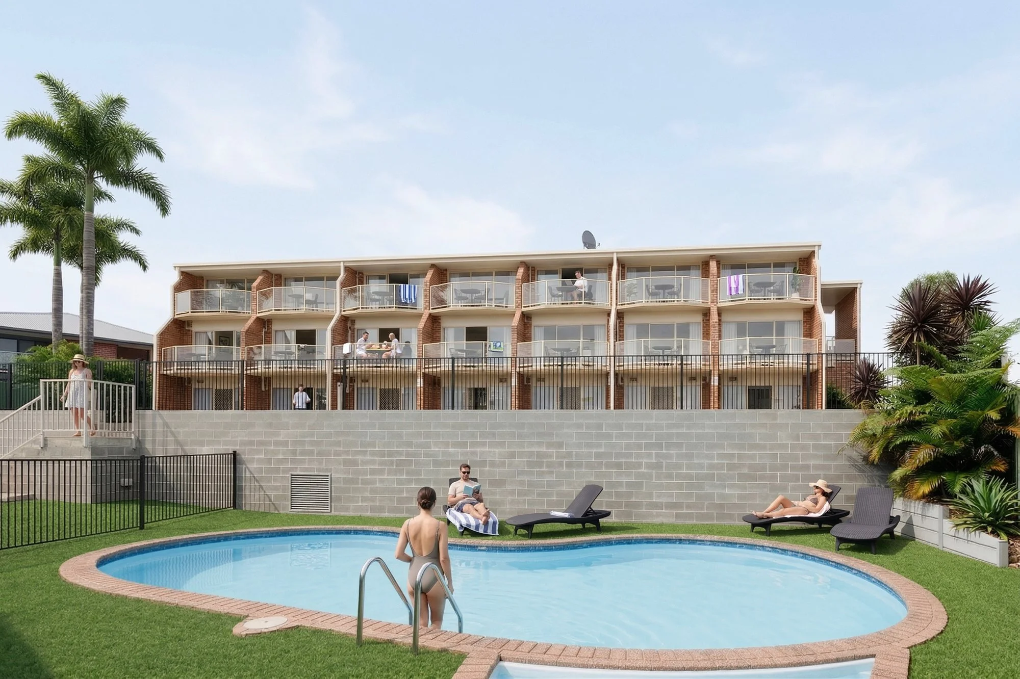 People relaxing around a swimming pool in a hotel courtyard with a multi-story brick hotel building in the background.