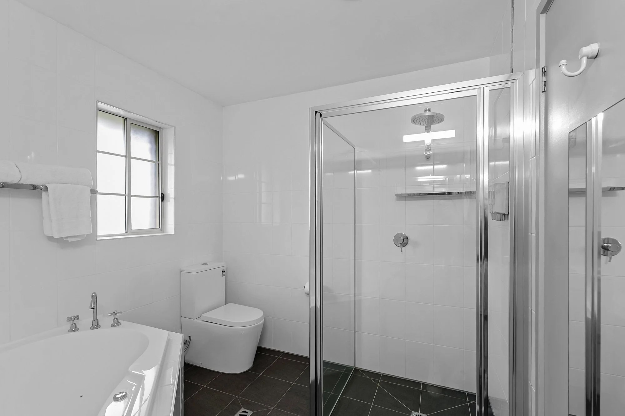 Hotel Photography.Contemporary hotel bathroom featuring walk-in shower and spa bath.