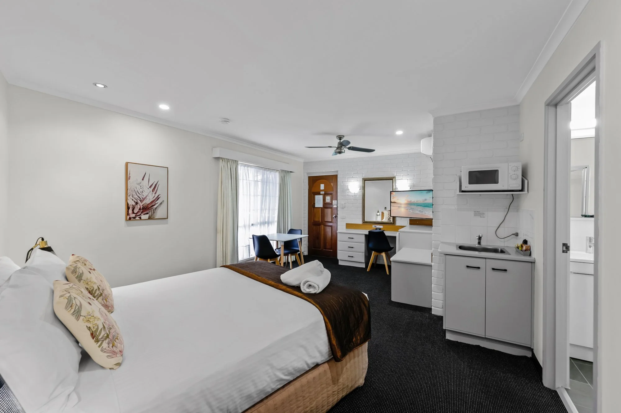 Cozy hotel suite bedroom with king bed, modern finishes.
