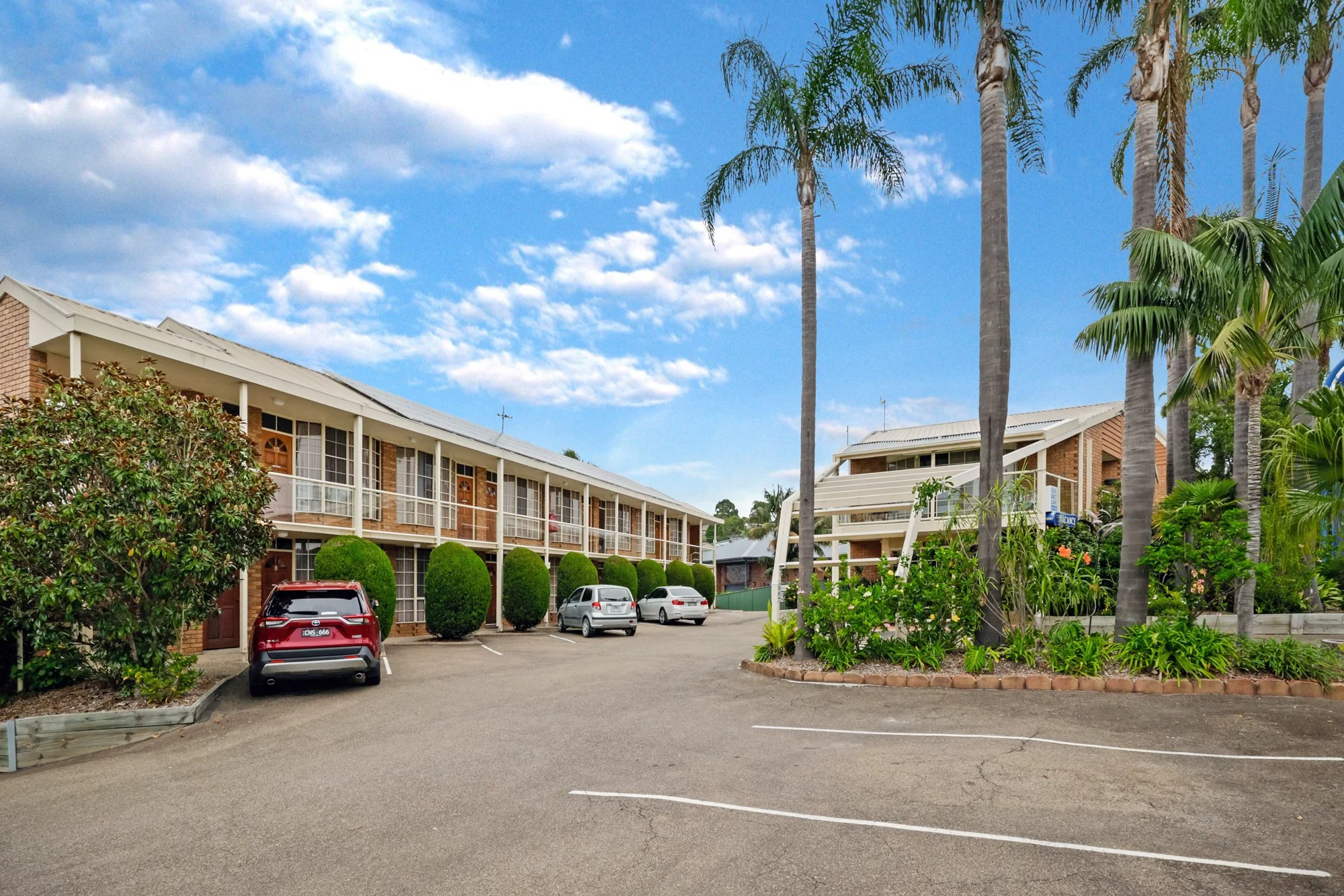 Hotel Photography. Blue sky holiday resort. exterior from carport to hotel rooms.