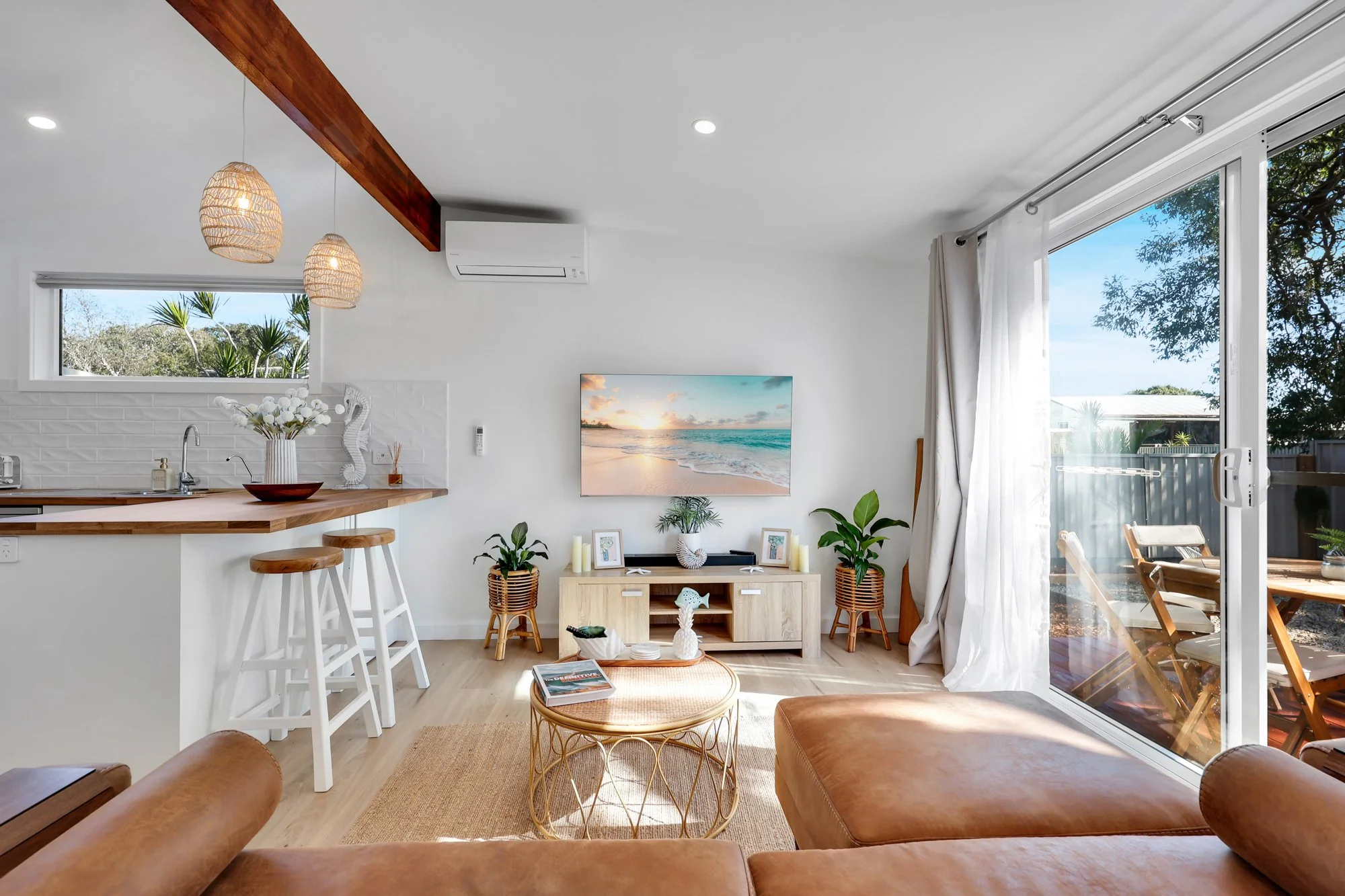 Bright Airbnb living room with modern timber flooring and a welcoming layout styled for short-stay comfort.
