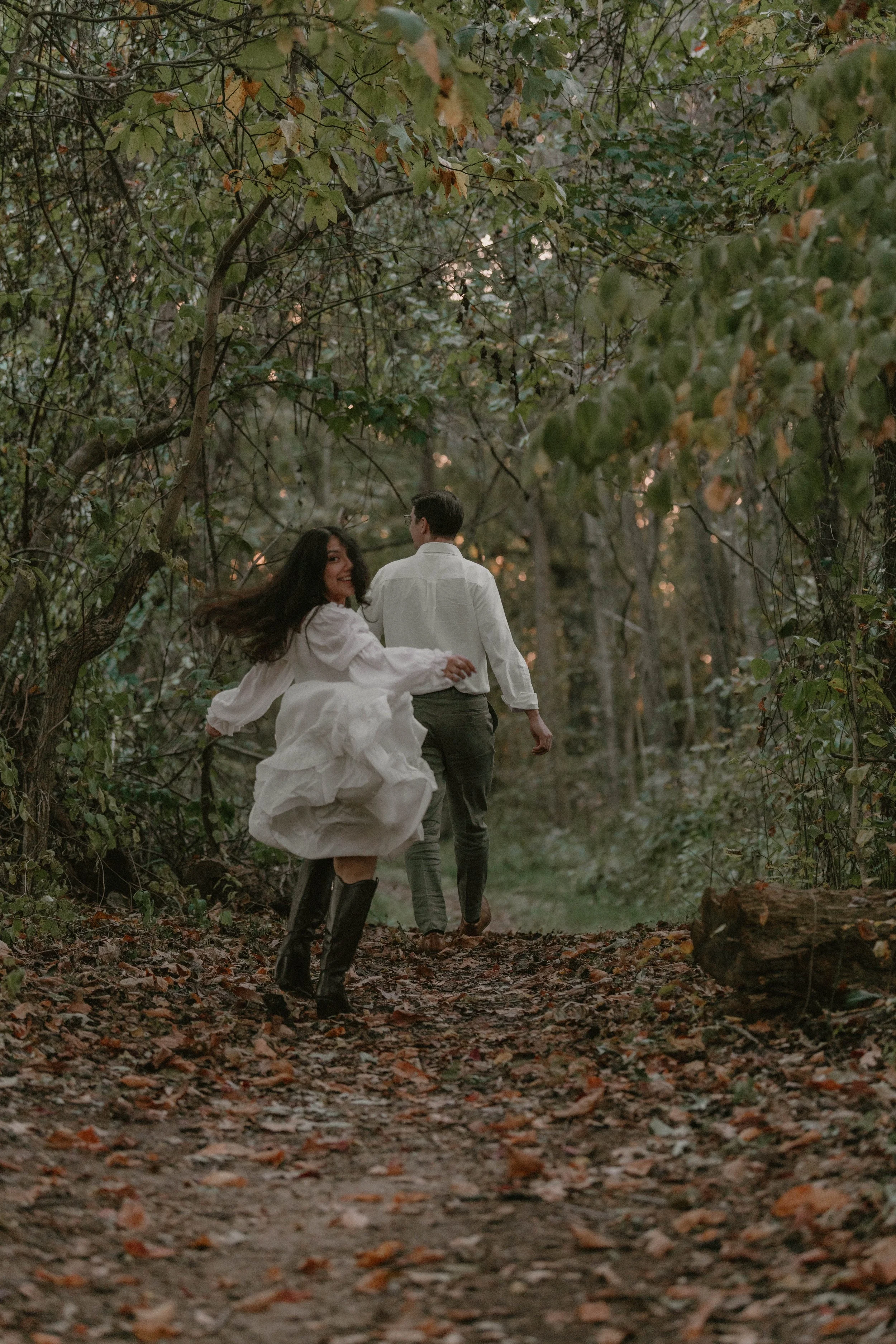 Engaged couple walking along a wooded trail during a green, film-inspired engagement session - Olea & Co Photography - Southern Maryland Engagement Session