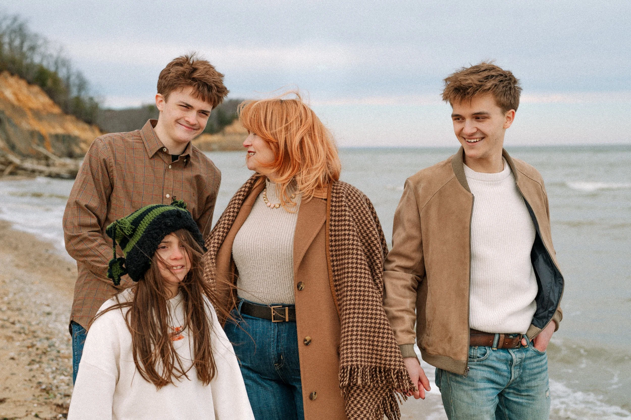 Mother walks with her older children during a family portrait session in Southern Maryland at Calvert Cliffs State Park