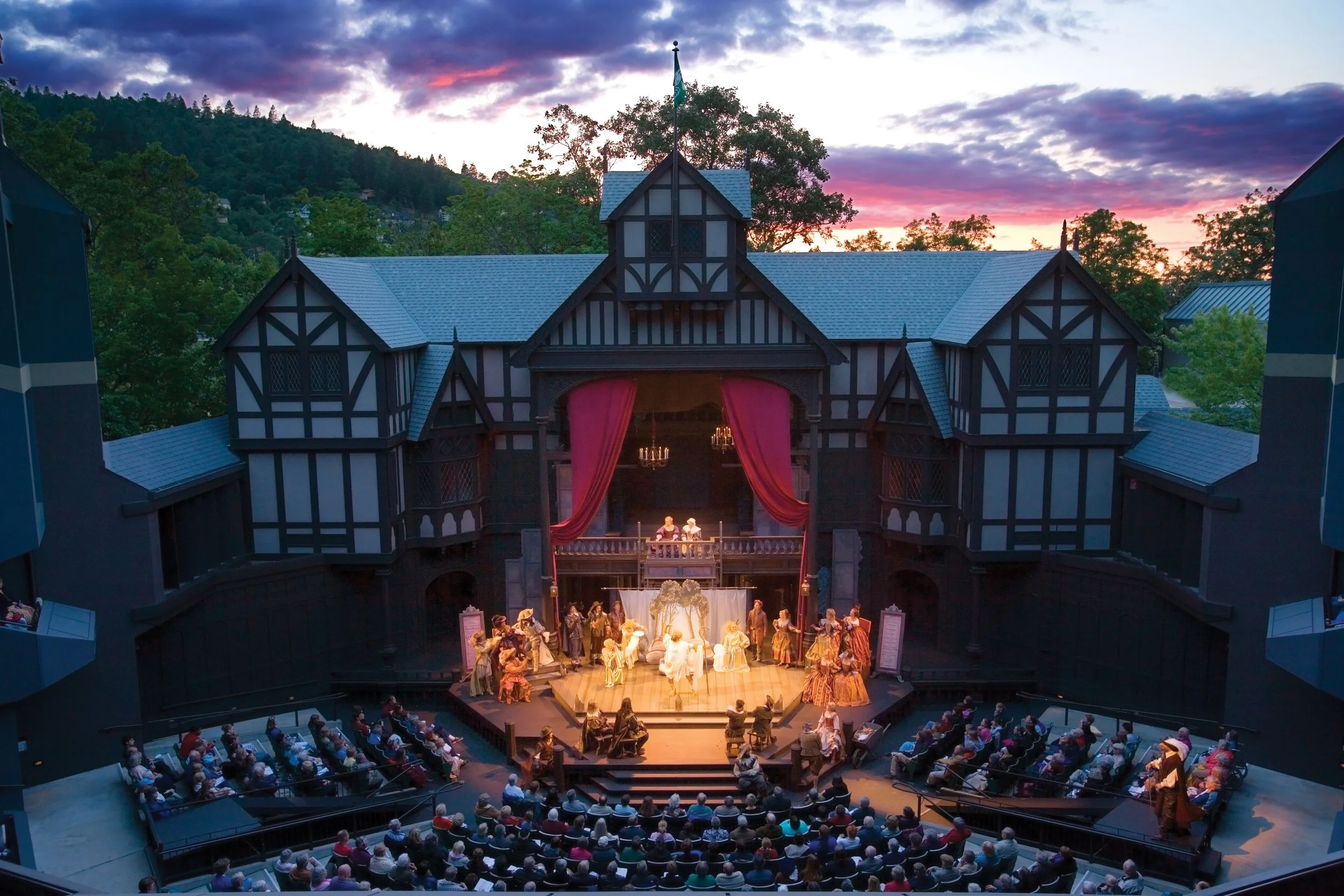 Image of the outdoor Oregon Shakespeare Festival Allen Elizabethan Theatre in Ashland Oregon mid-play at sunset