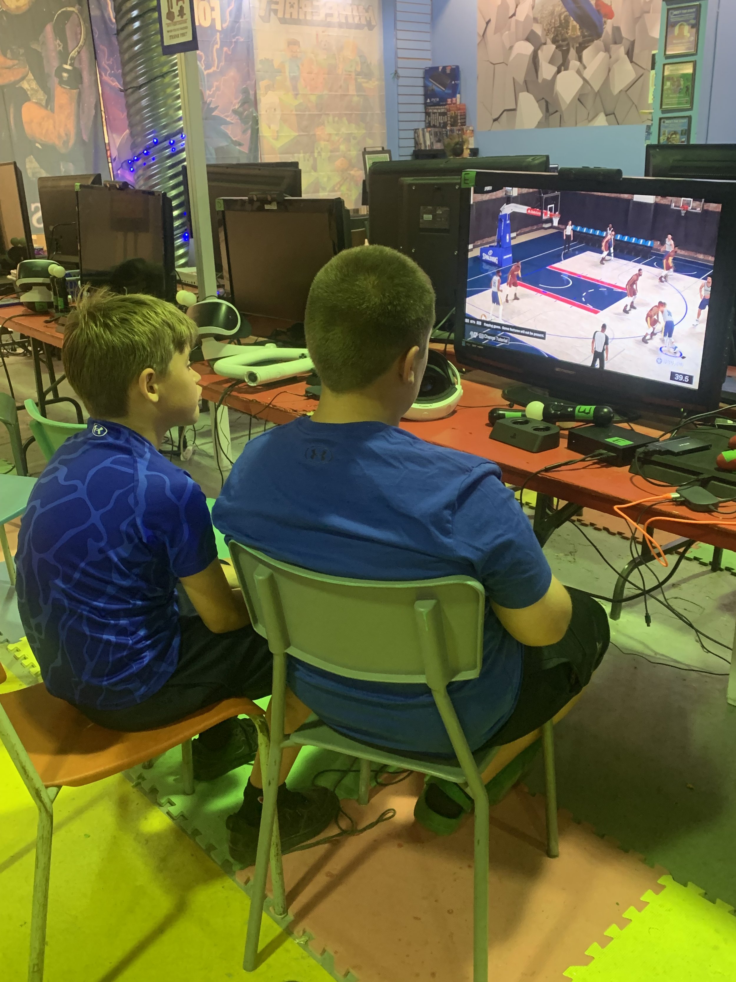 Two boys playing a basketball video game at an arcade center.