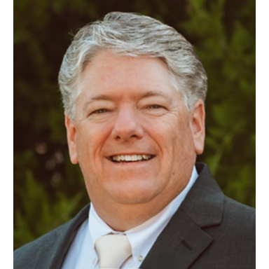 Smiling person in suit with outdoor background
