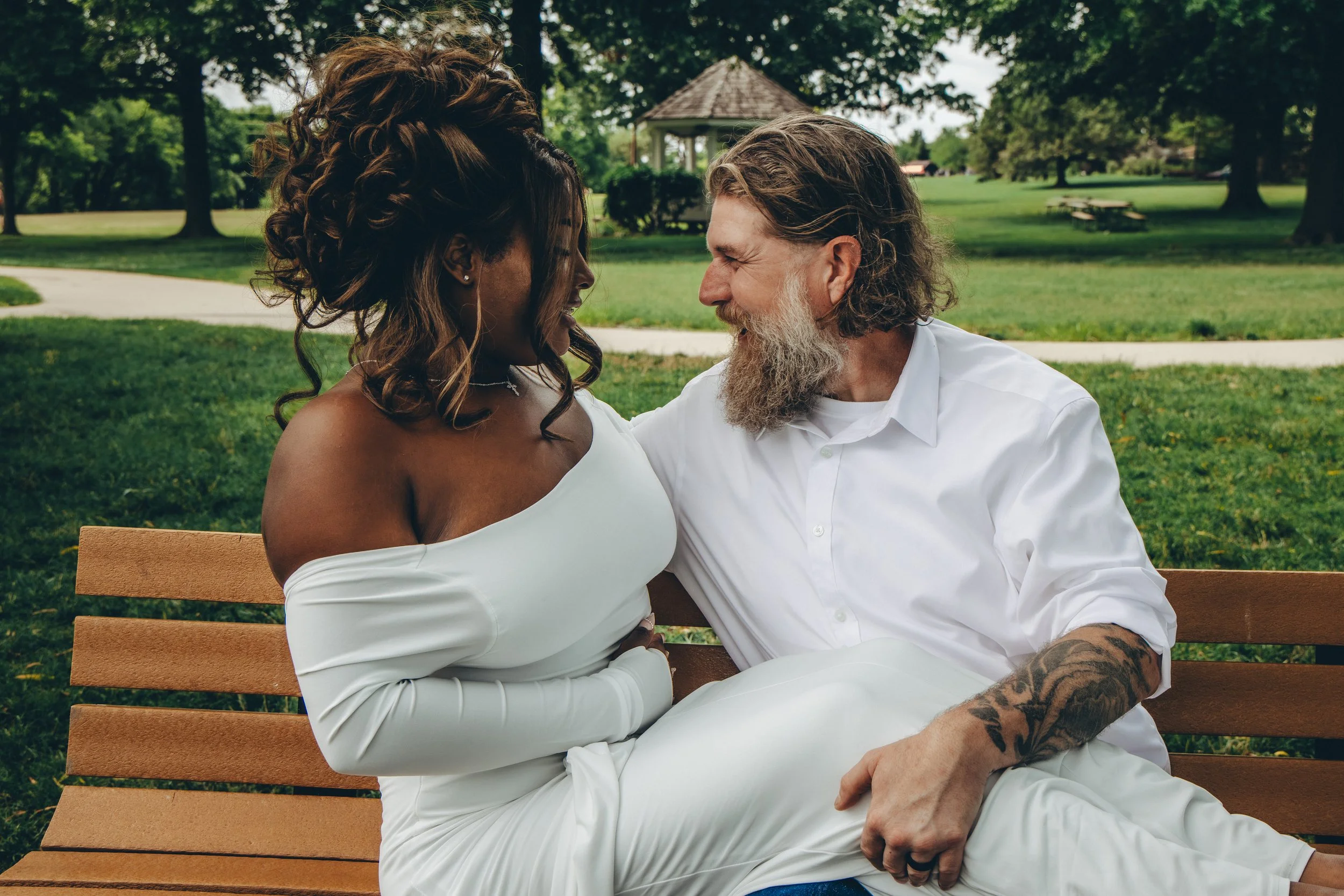 bride and groom laugh with each other on bench