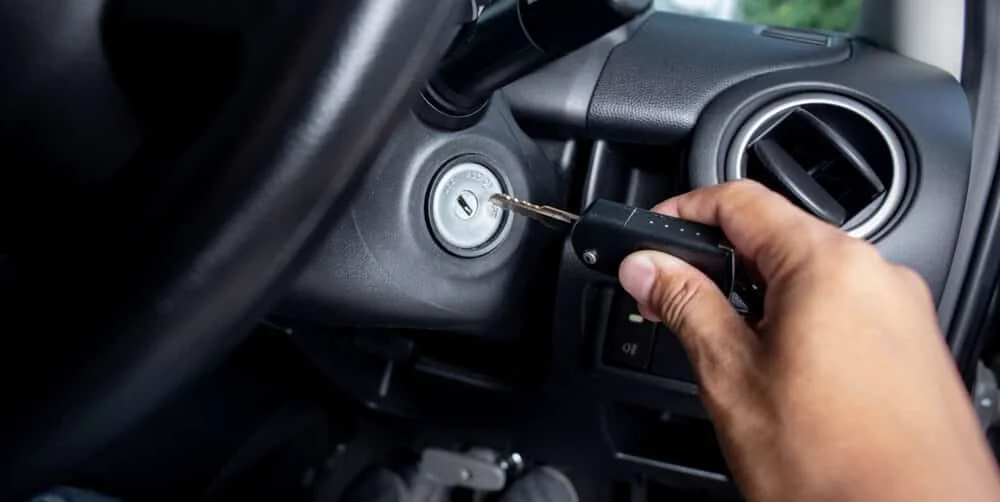 A person has used a key to turn off a truck's ignition switch.