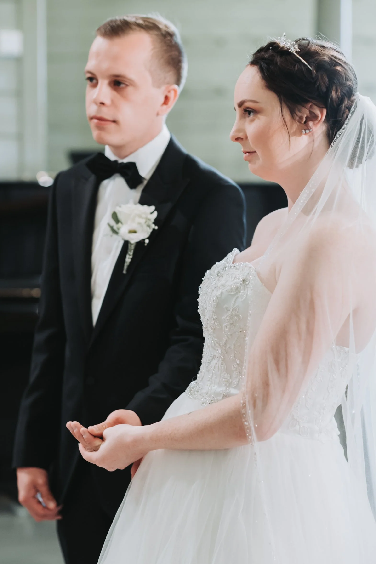 Bryllupsseremoni med brud og brudgom som holder hender under vielsen.