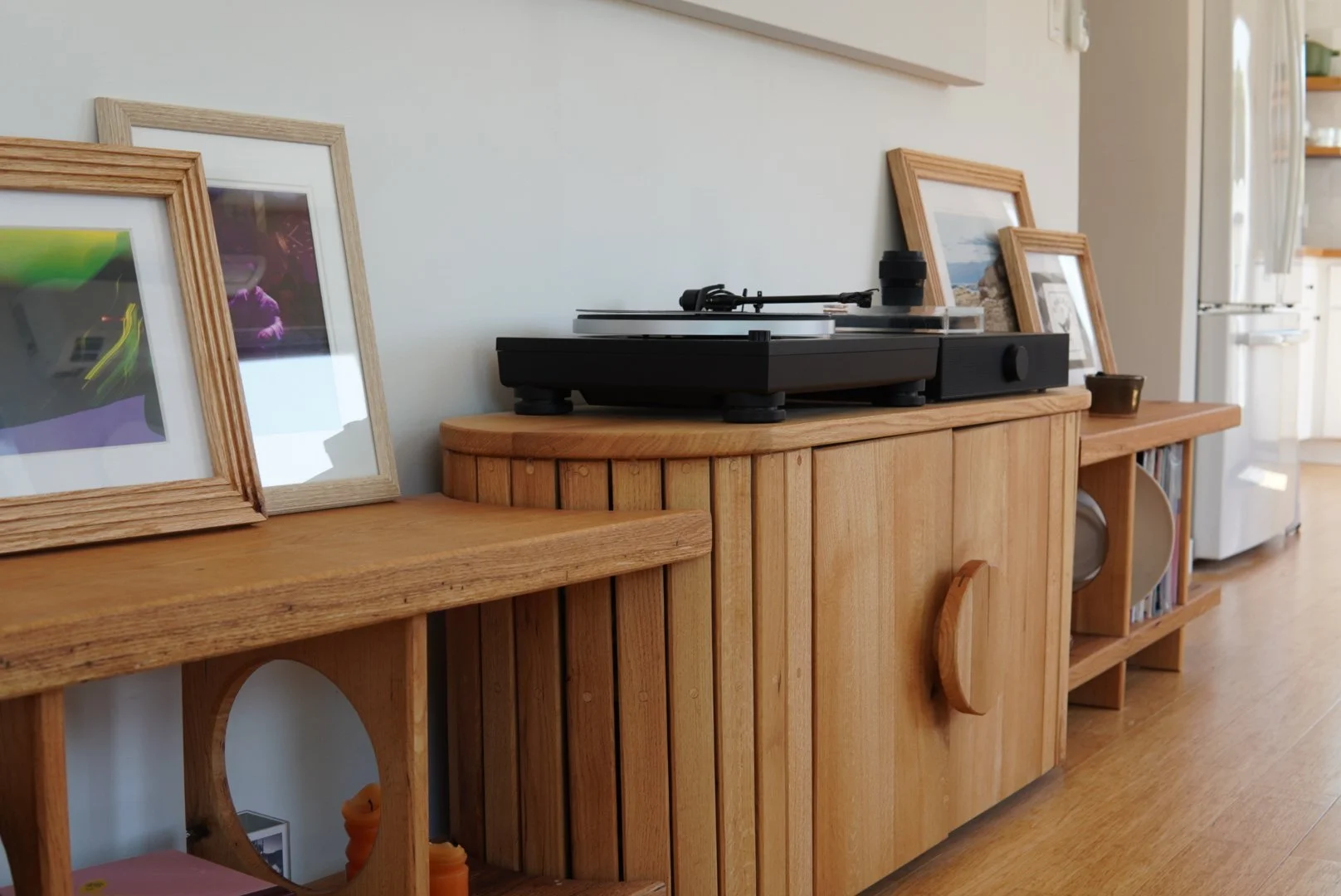 Turntable on a custom wooden cabinet to store records in a modern cozy home interior.