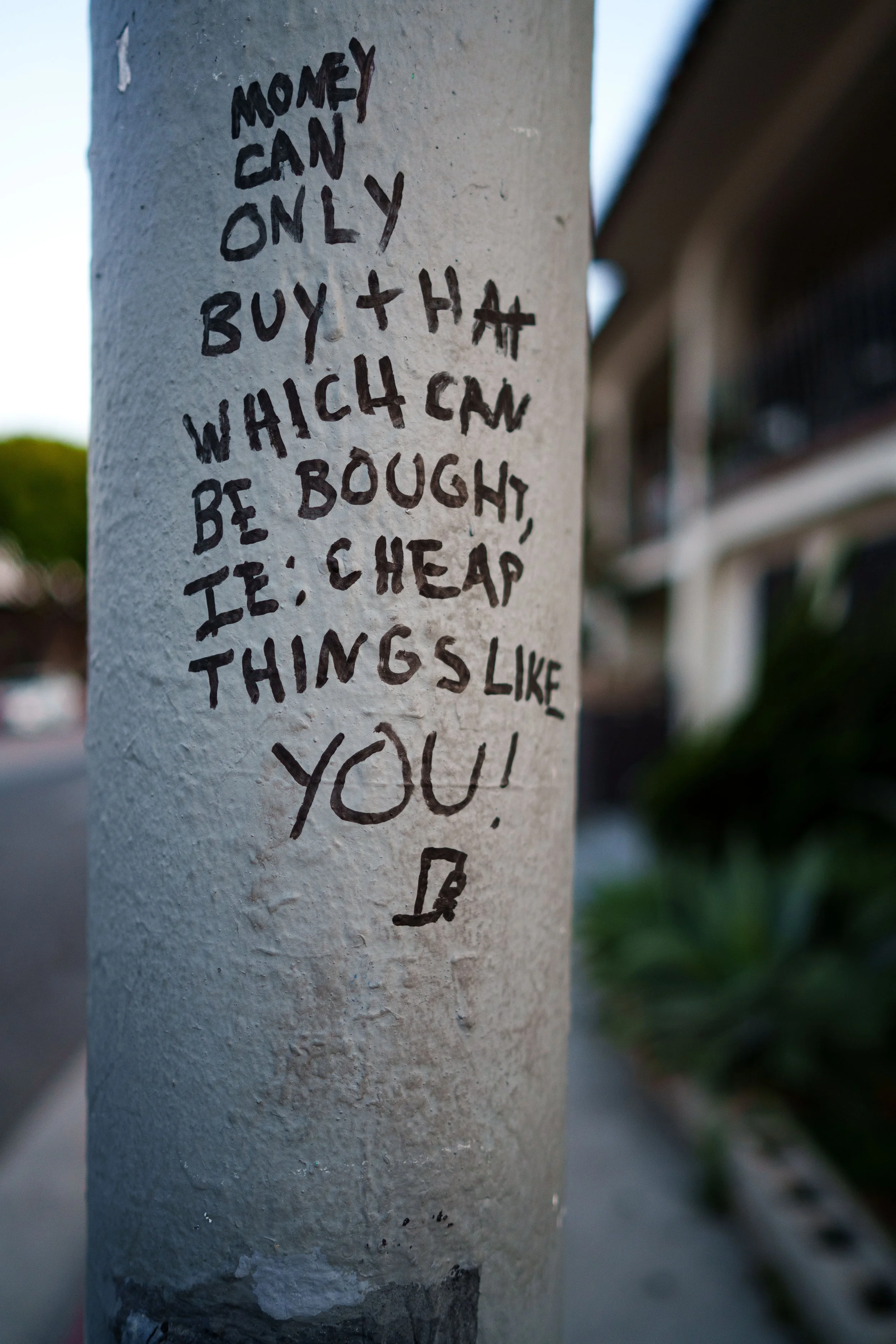 Hand written words on a traffic light pole