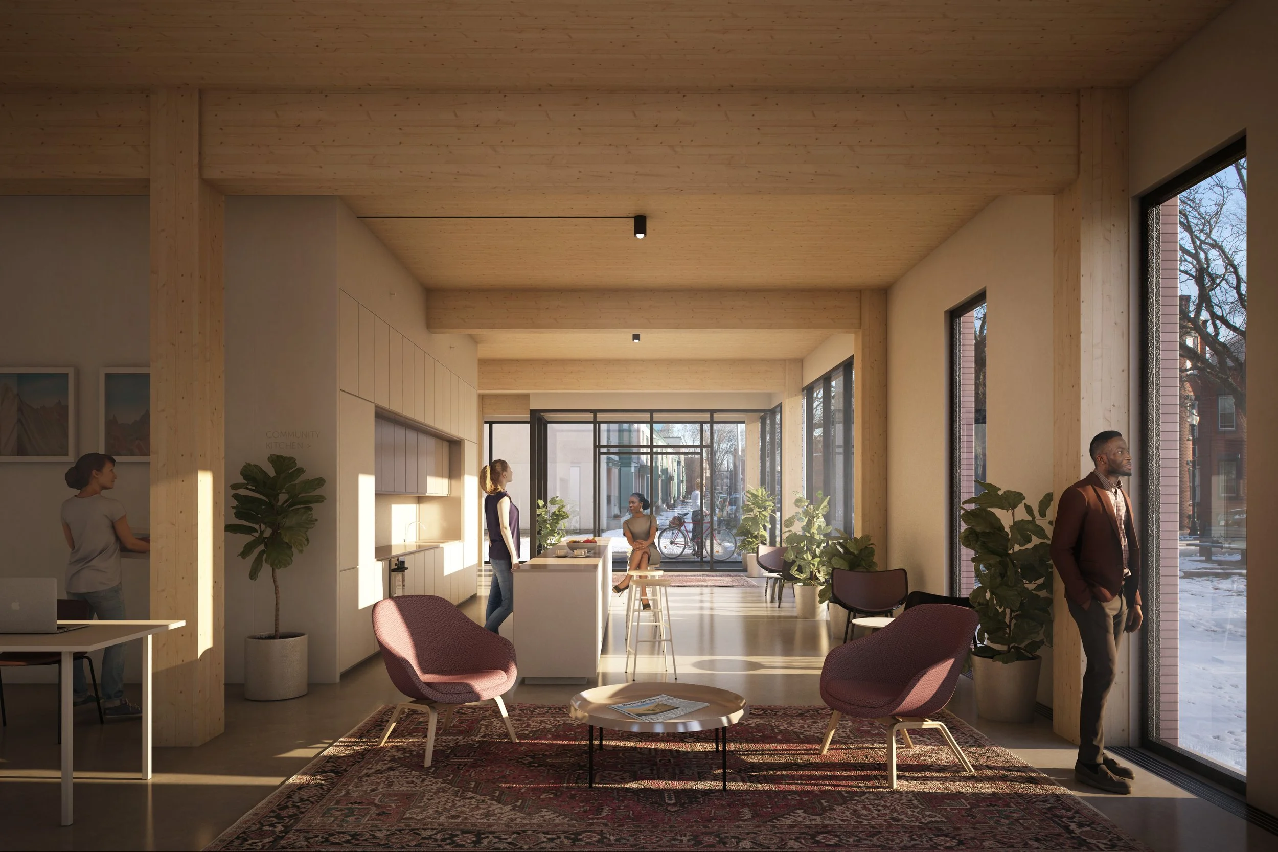 Interior view of a modern, well-lit communal space with large windows, wooden ceiling, and furniture including pink armchairs, potted plants, and a rug. Several people are present, engaging in various activities.