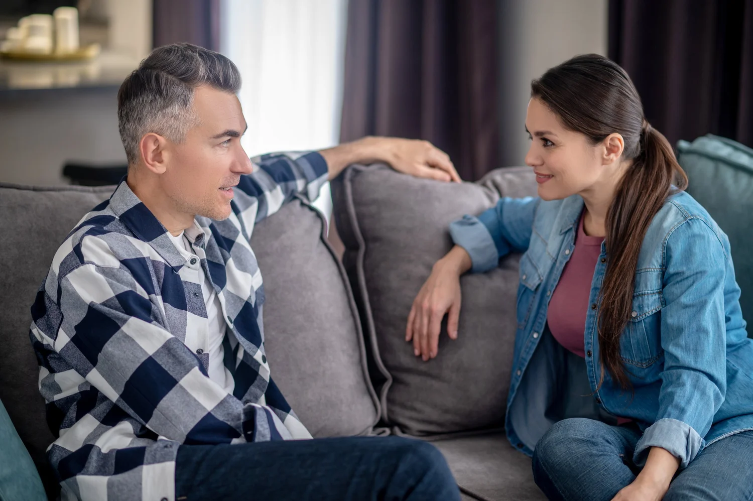 A couple sitting together on a couch, talking