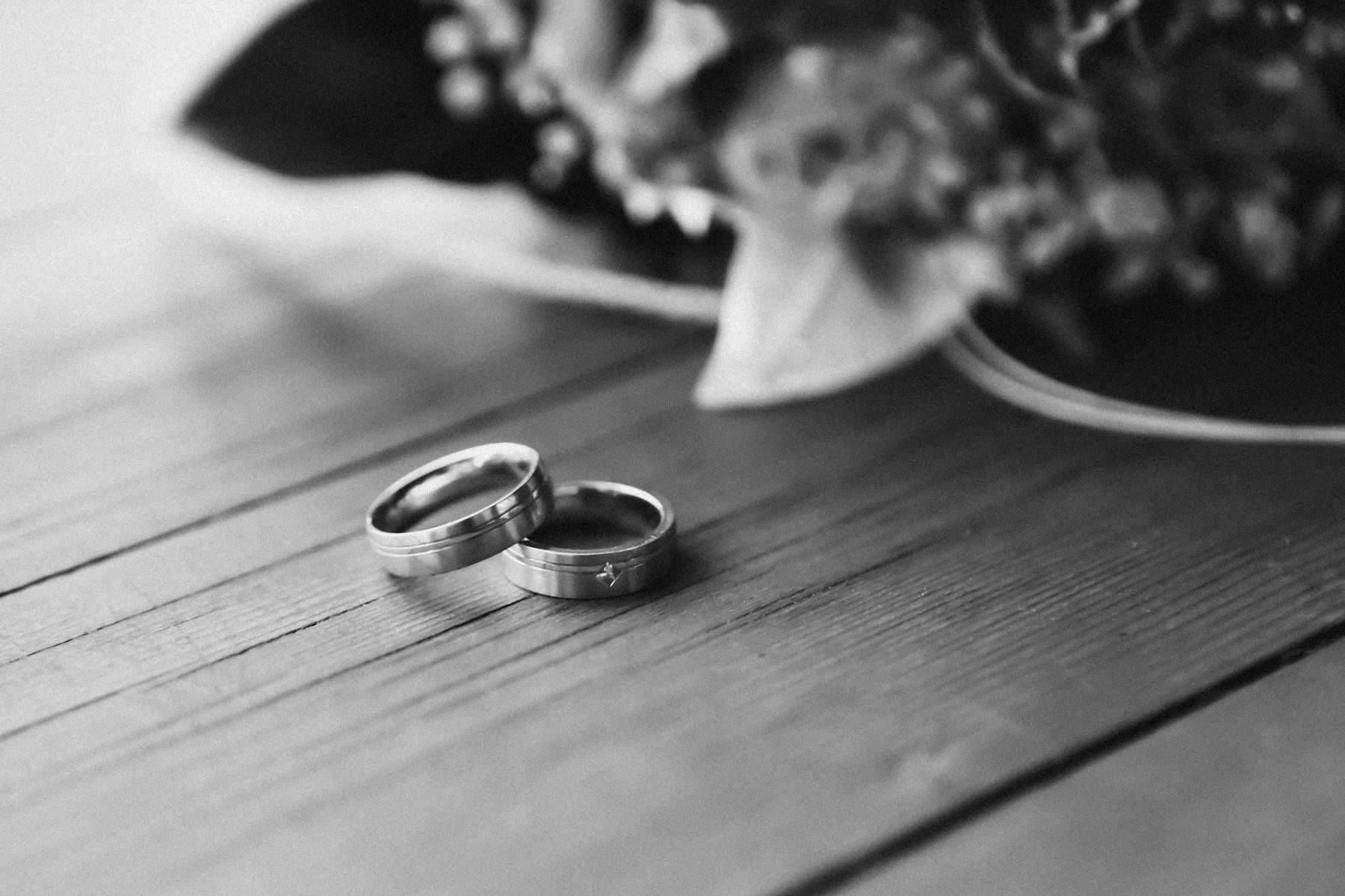 Two wedding rings resting on a wooden table