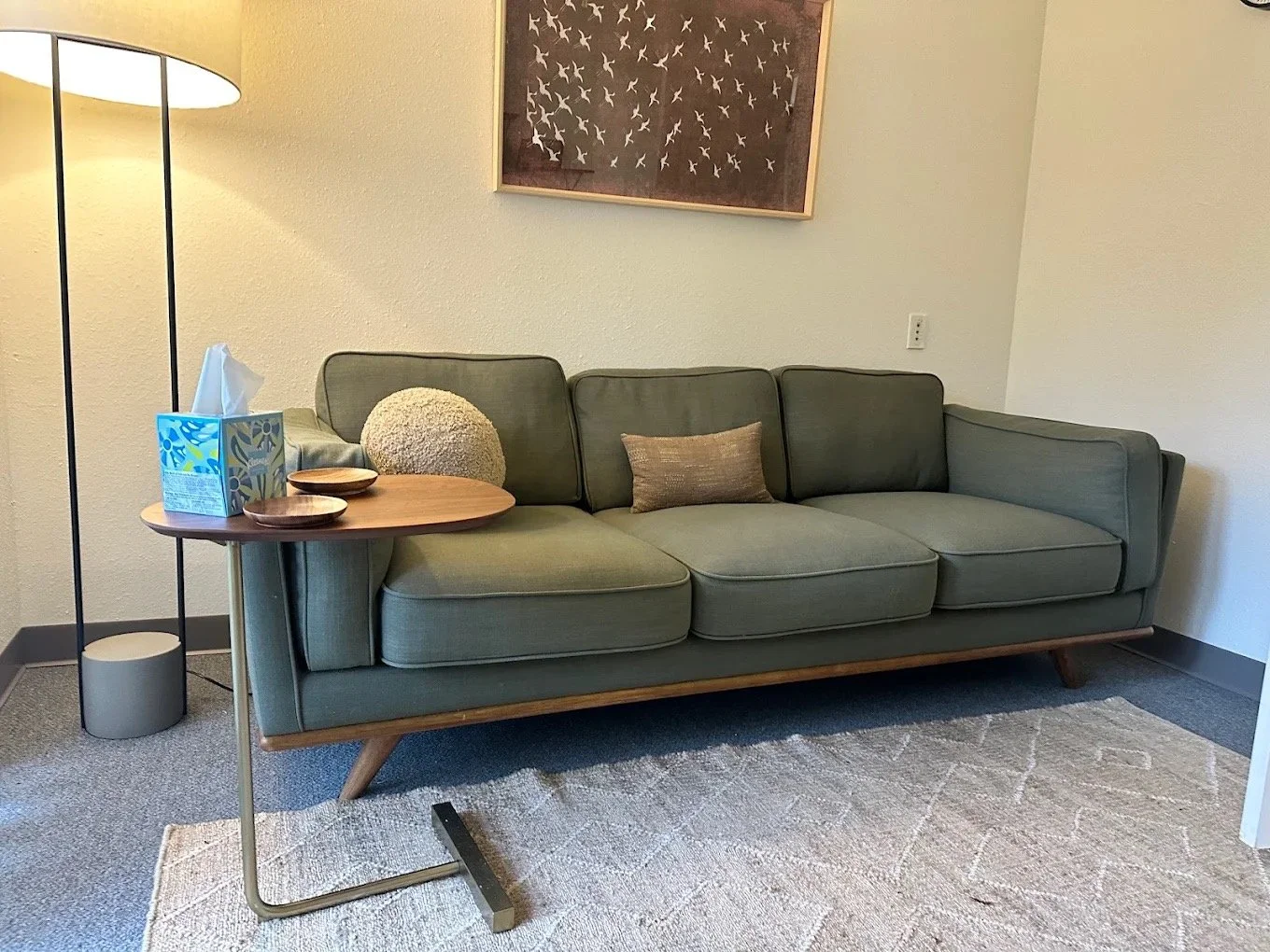 A therapy room at his Austin office, with a green sofa and a floor lamp