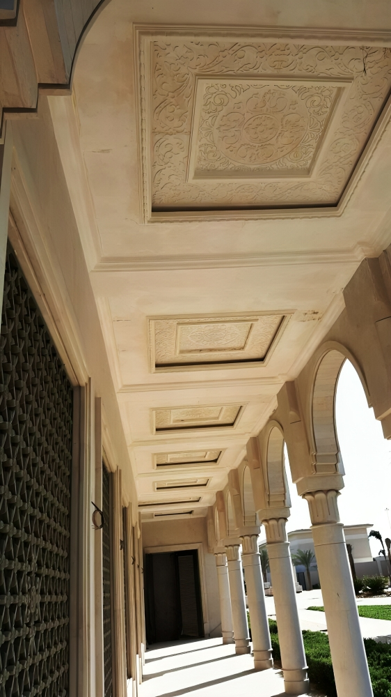 Architectural hallway with ornate ceiling and arched columns