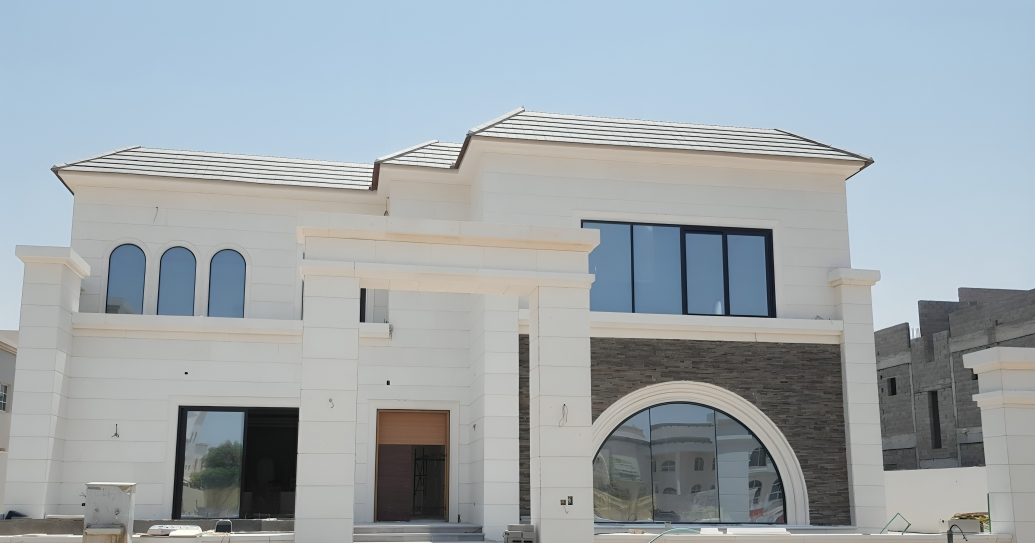 Modern two-story house with arched windows, under construction, featuring a white facade and brick accents.