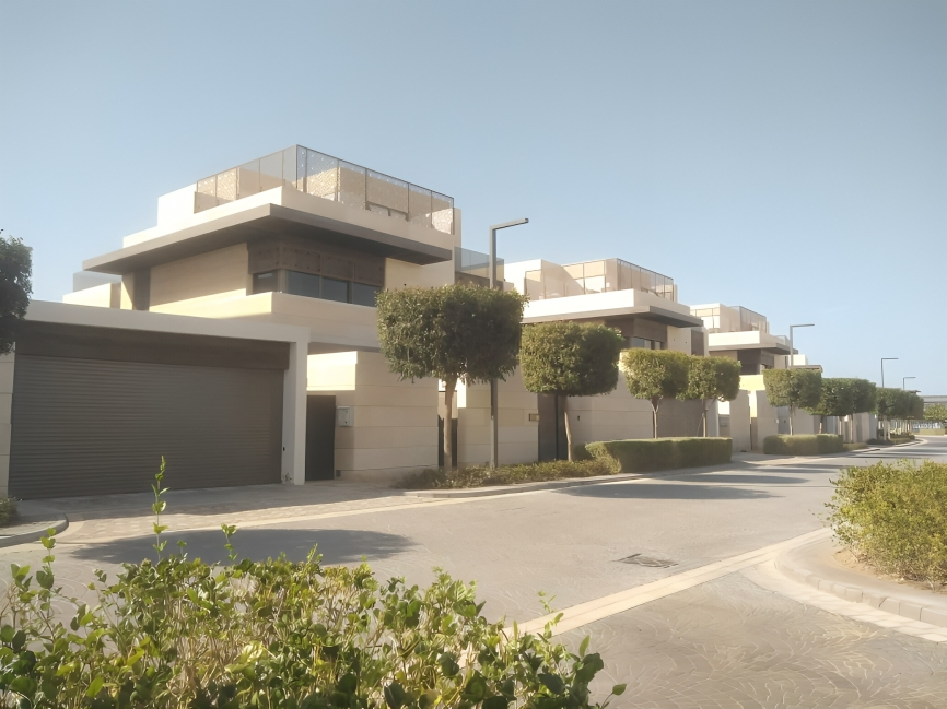 Modern residential homes with flat roofs and small trees in a suburban neighborhood on a sunny day.