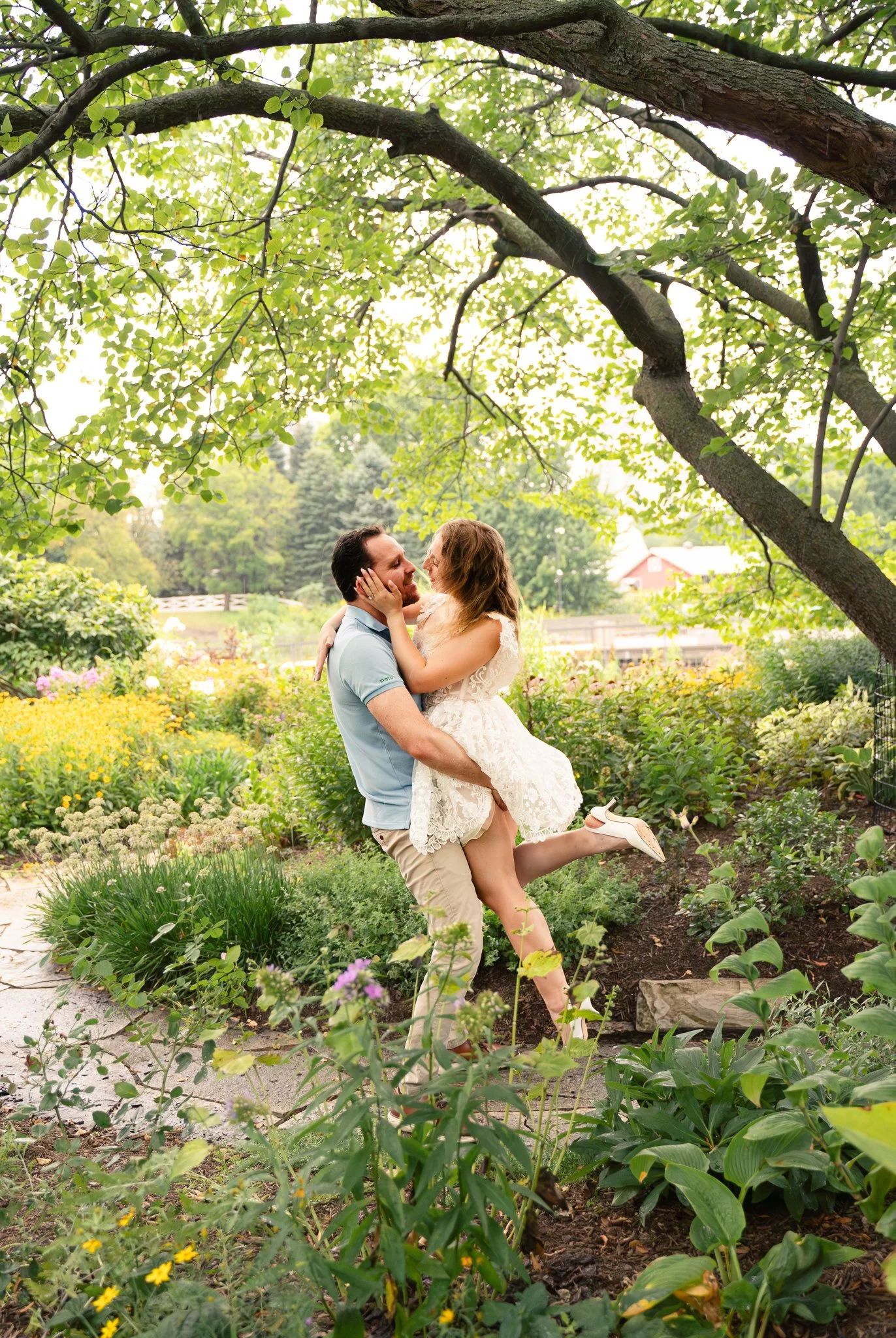Lincoln Park Chicago Illinois Engagement Photographer | Bride in lace white dress picked up by groom in secret garden | Midwest Wedding and Engagement Photography Sessions