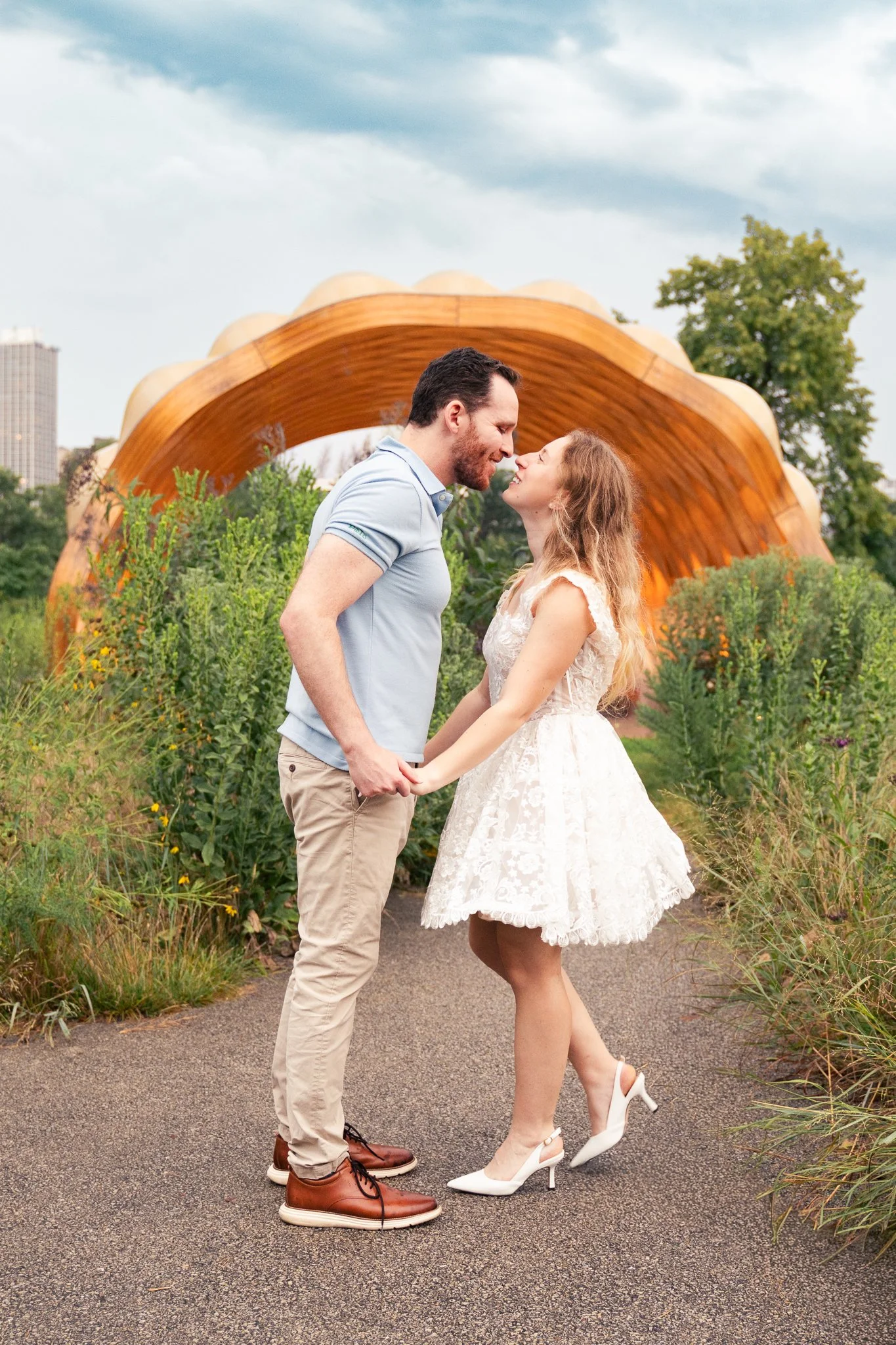 Lincoln Park Chicago Illinois Engagement Photographer | Bride in lace white dress holding on to grooms arm, Honeycomb in background | Midwest Wedding and Engagement Photography Sessions