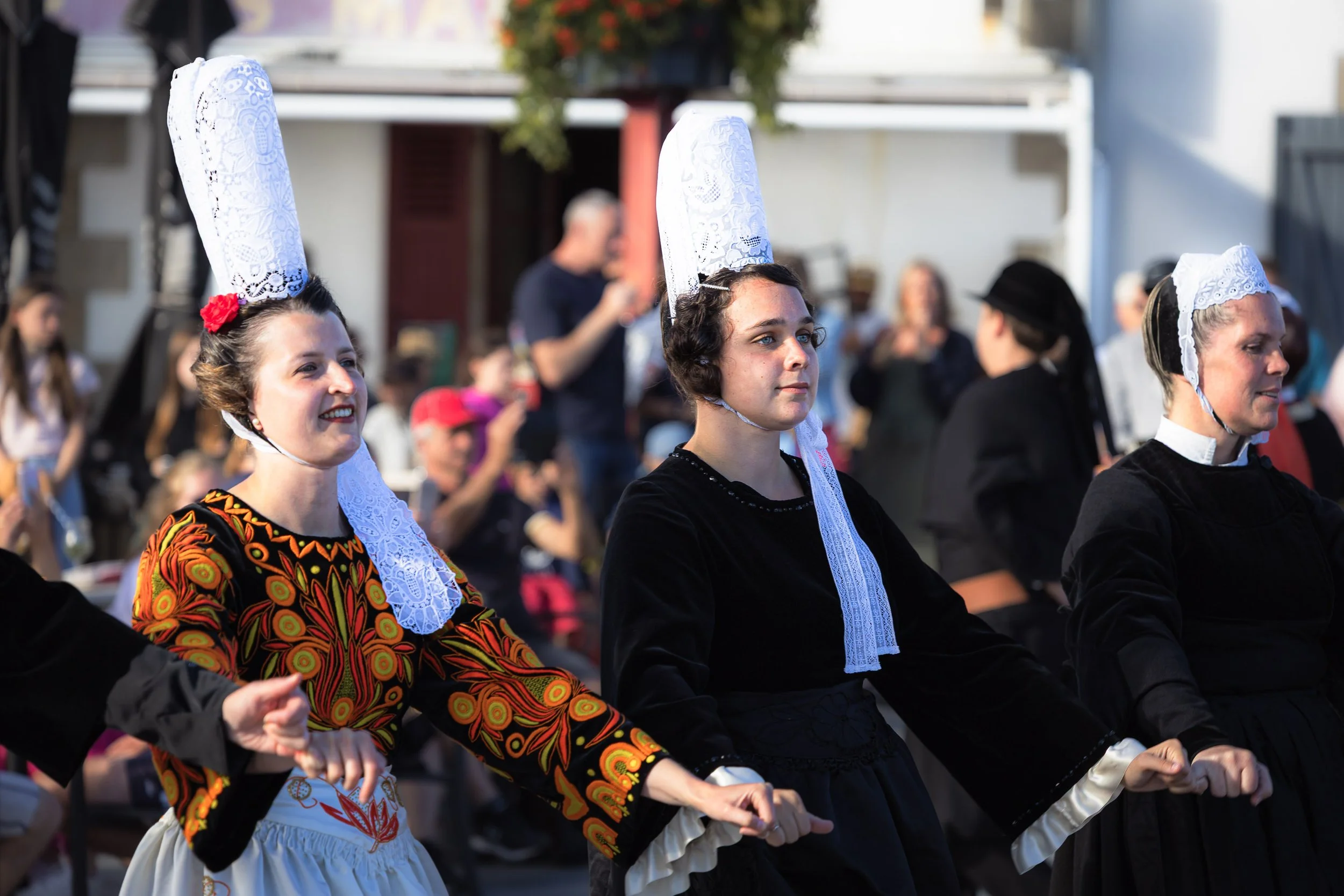 Des femmes en costume traditionnel breton lors d'un festival.
