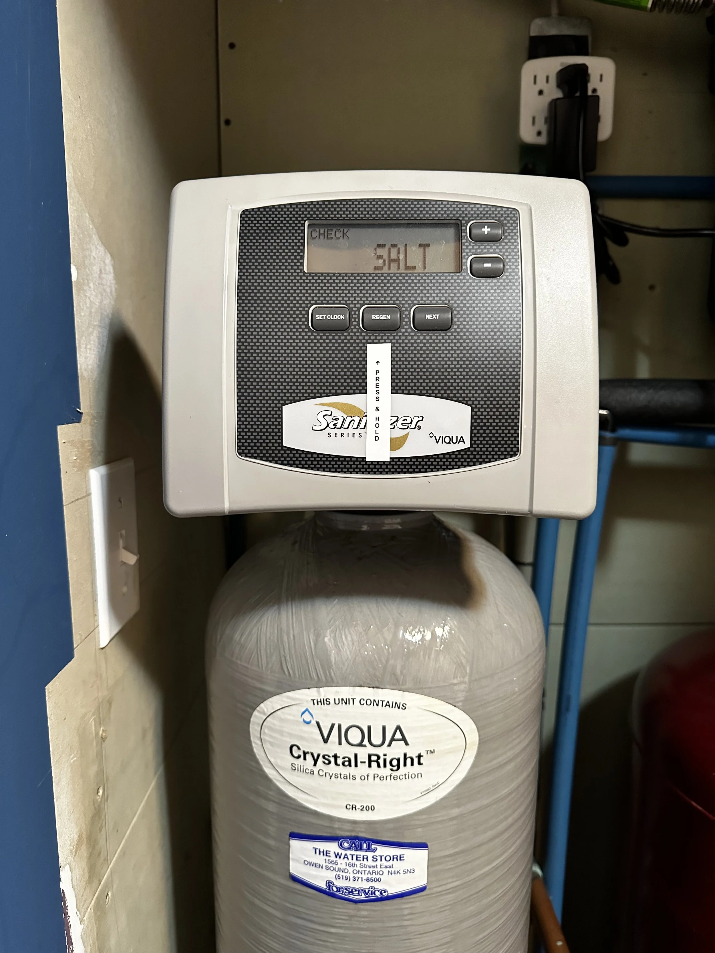 A water softener control valve displays the word 'SALT' on the screen.