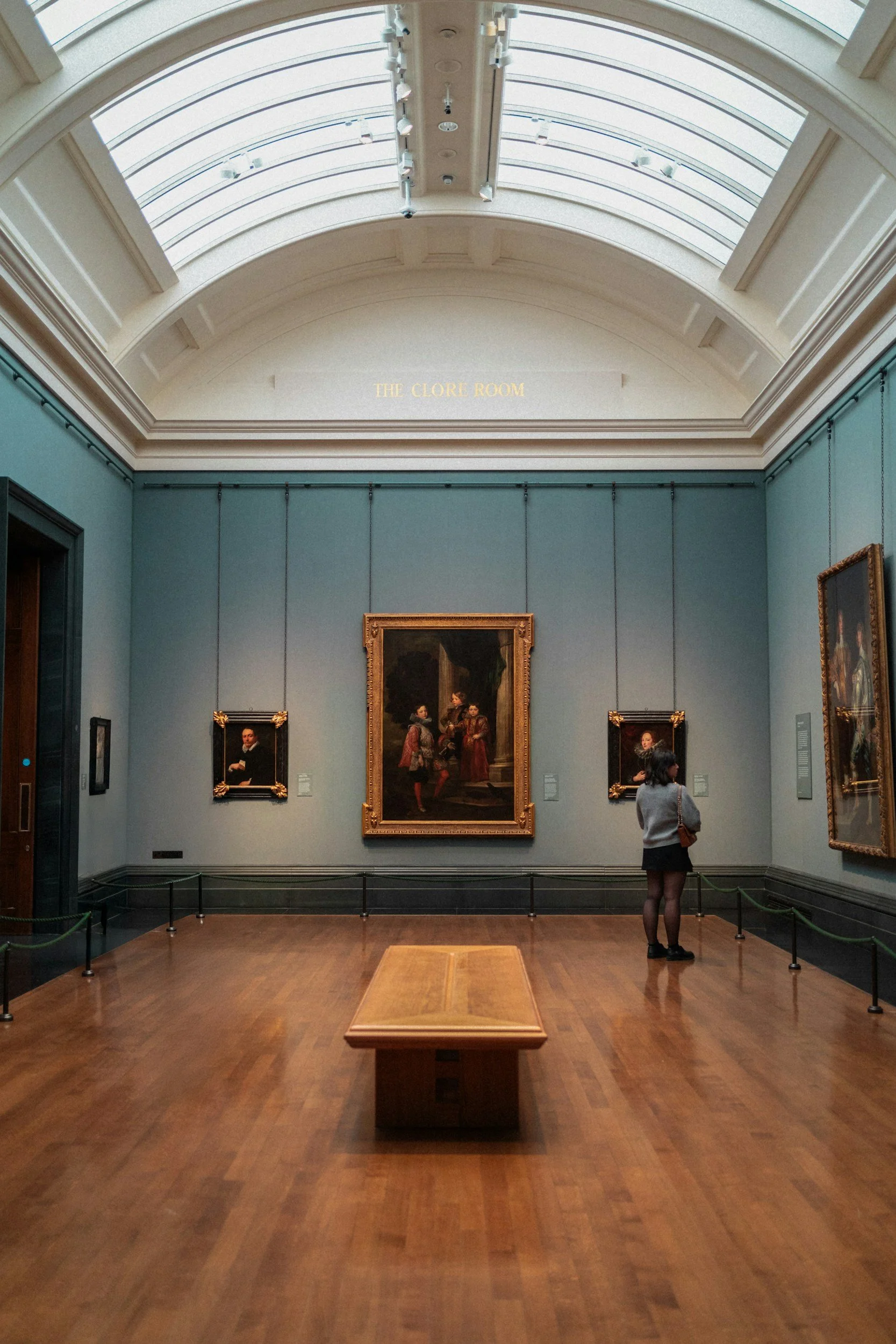 A quiet, skylit museum gallery with paintings and sculpture from across the collection.
