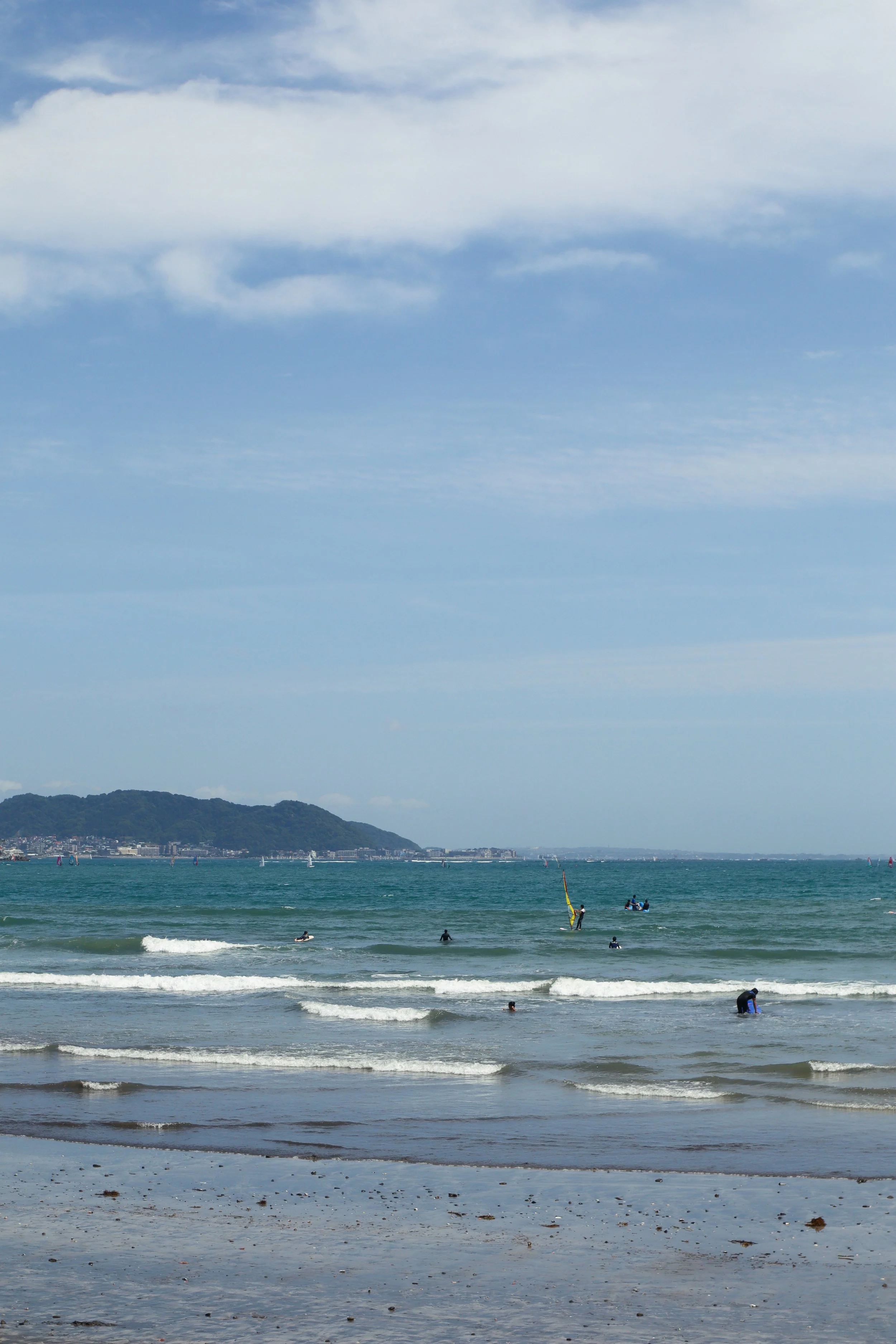 Yuigahama Beach: A perfect day trip from Tokyo, featuring sandy shores, azure waters, and surfers in Kamakura, Japan.