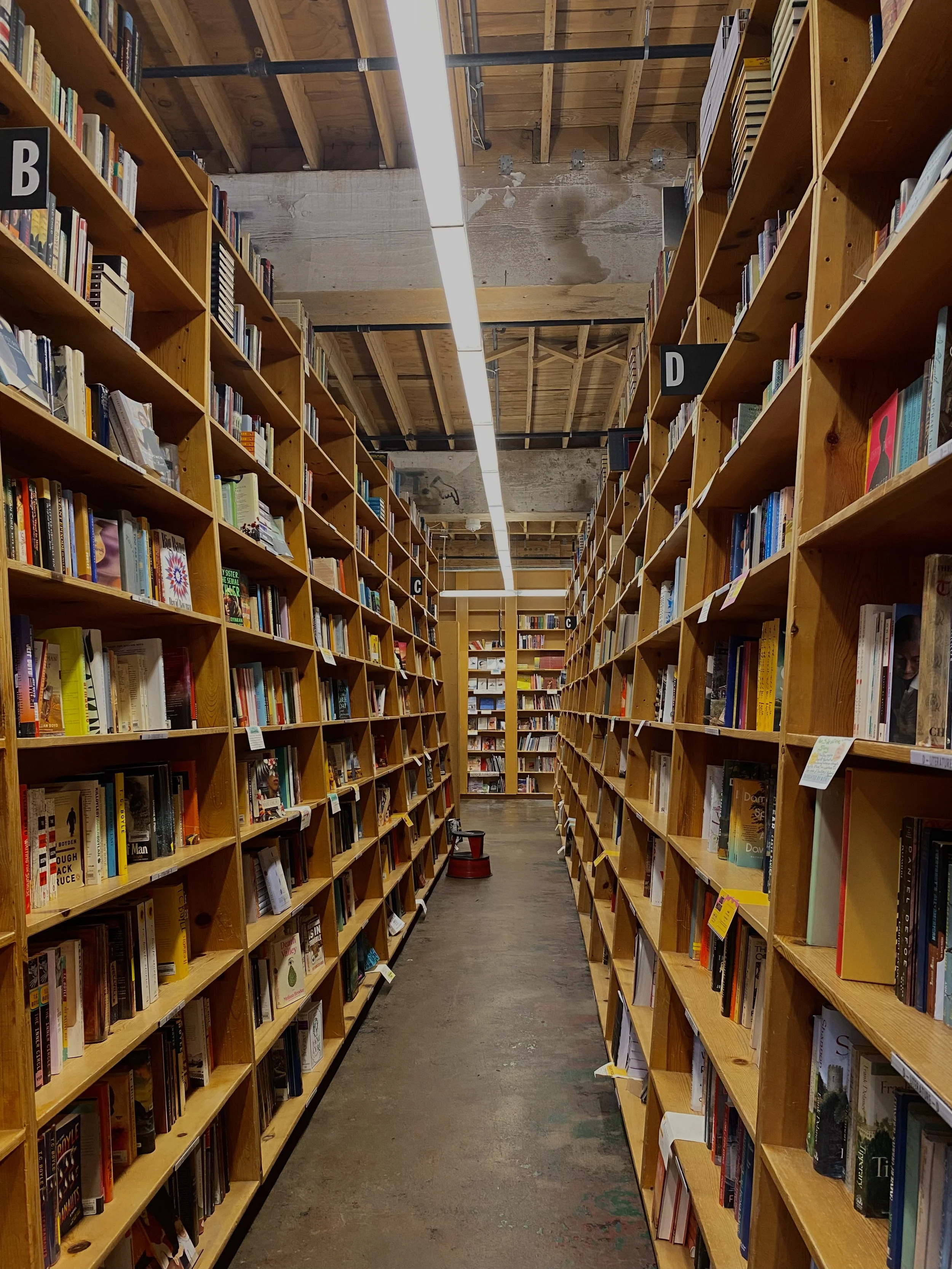 A cozy and inviting interior view of Powell's Books in Portland, Oregon, featuring shelves filled with books and a welcoming atmosphere. A literary stop on a perfect 4-day Oregon trip.