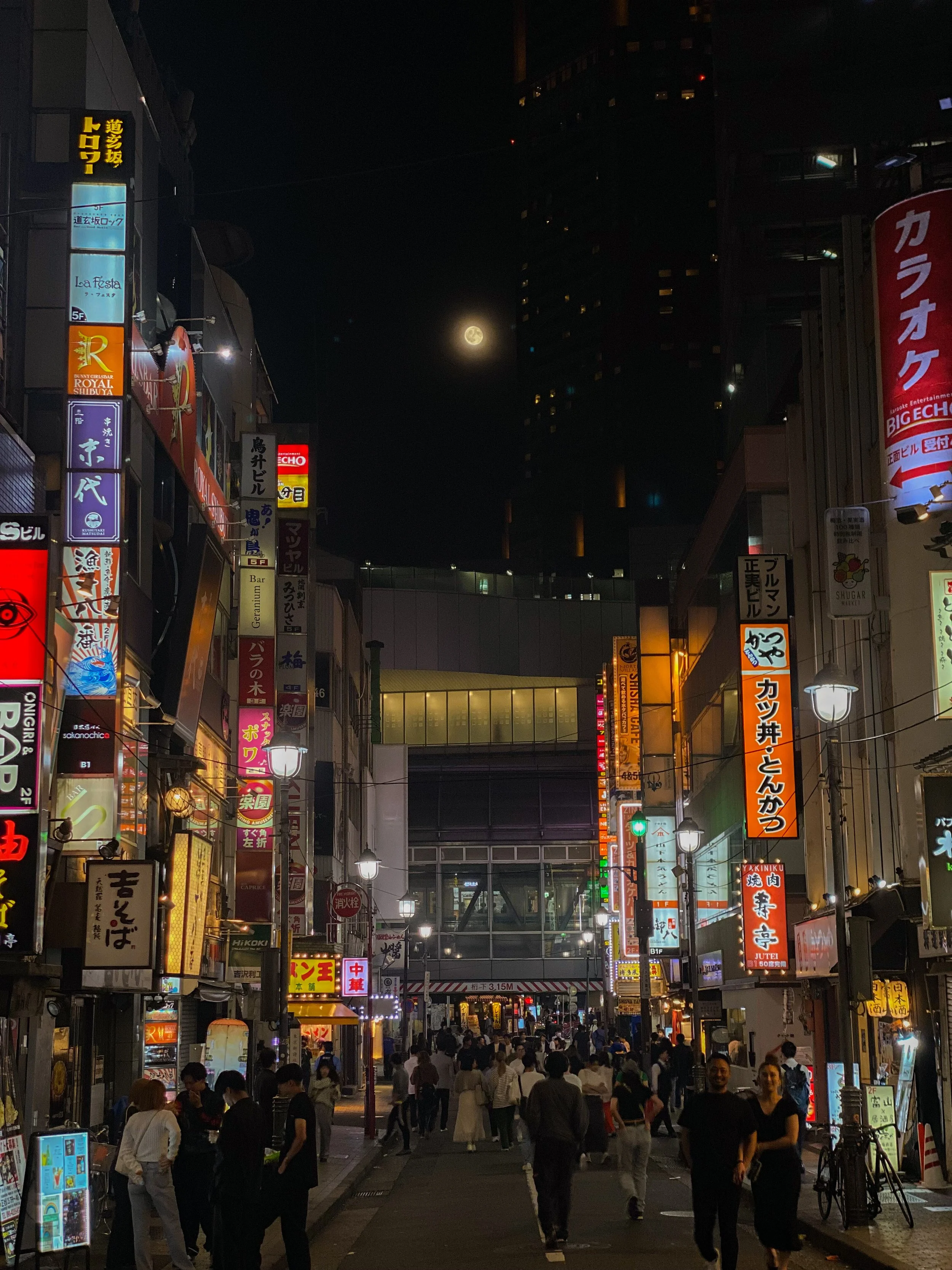Key stop on 48-hour Tokyo itinerary. Shibuya district, Tokyo, Japan. Famous Shibuya Crossing with crowds of pedestrians, vibrant neon lights, bustling shops, and iconic Hachiko statue.