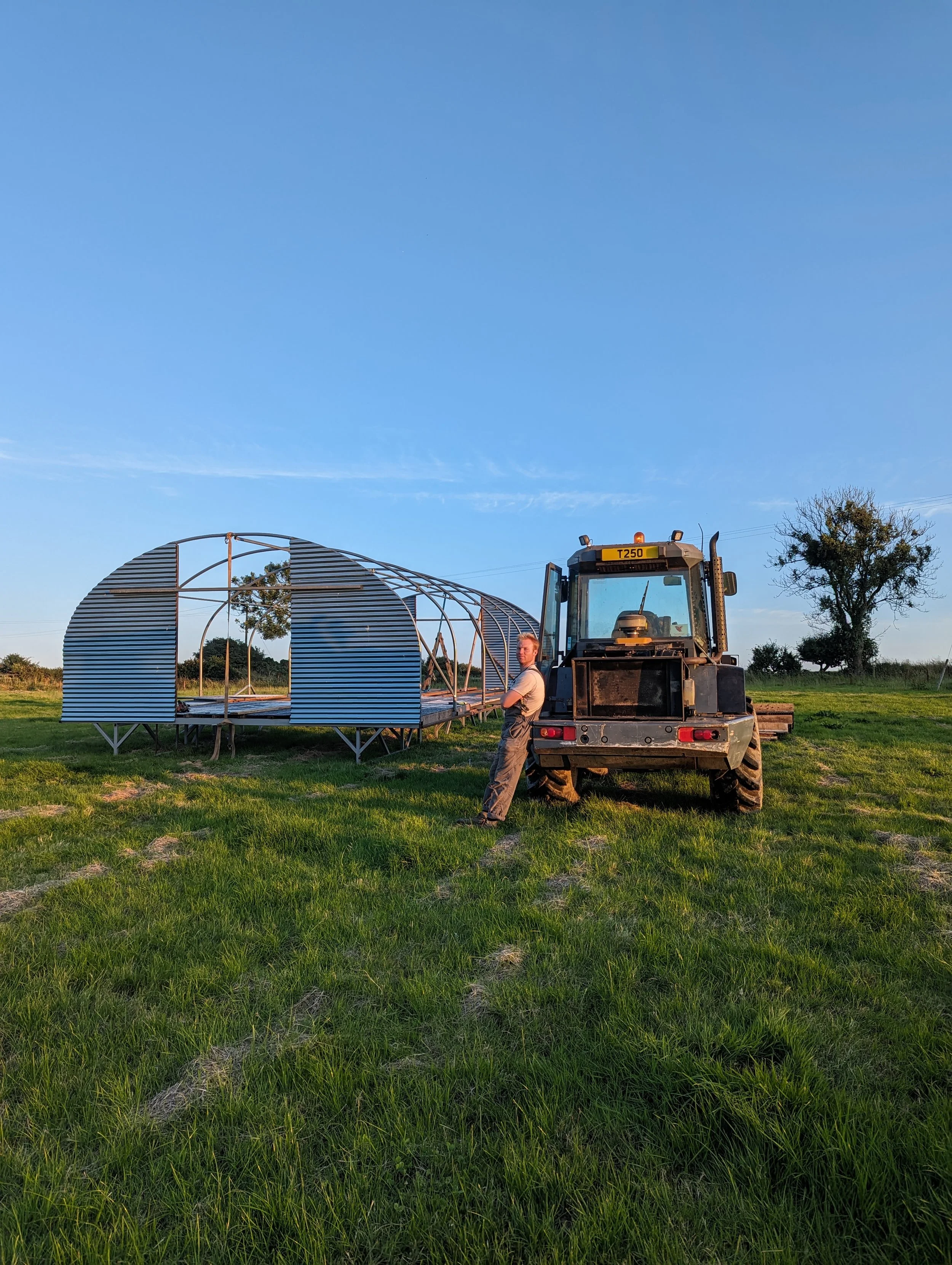 Man resting against digger in a field