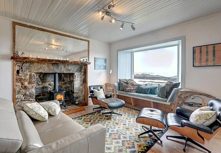 Open plan family / living room with stunning sea views, wood burning stove comfy sofas.