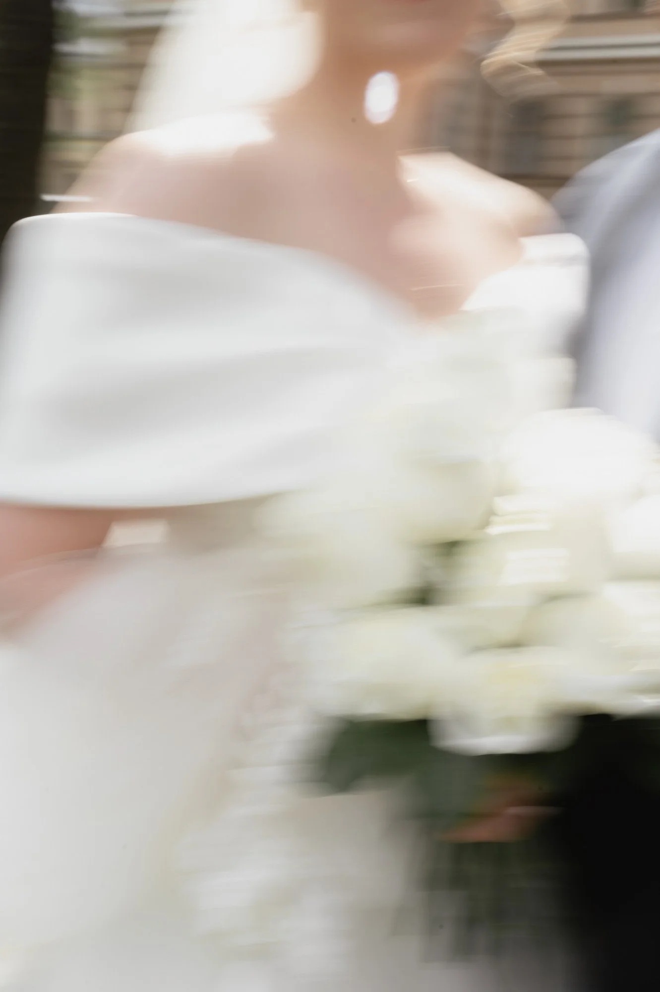 Epätarkka ja liikkuva lähikuva hääparista, morsian pitelee valkoista ruusukimppua