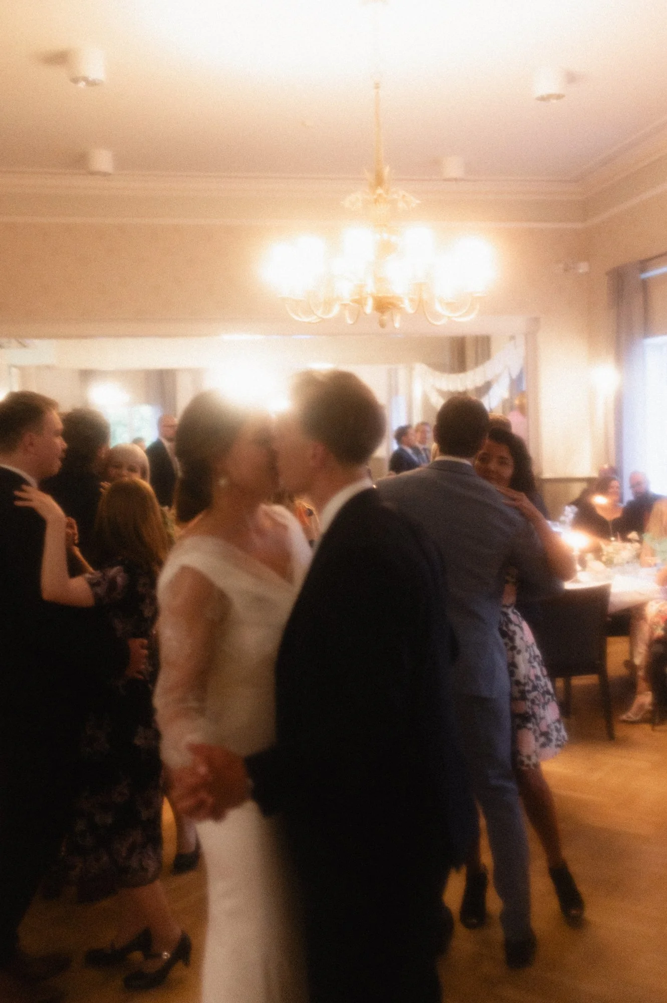 Upea hääjuhla suurikokoisella tanssilattialla, jossa pari tanssii ja muita juhlia vierailee ympärillä.