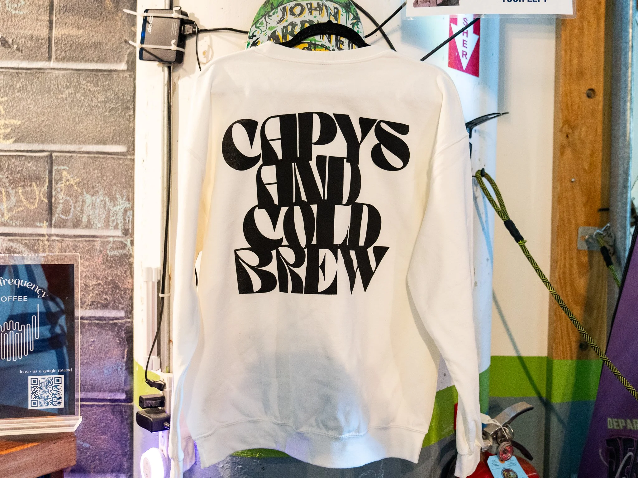 A custom sweatshirt that says "Capys and Cold Brew" with a custom logo.