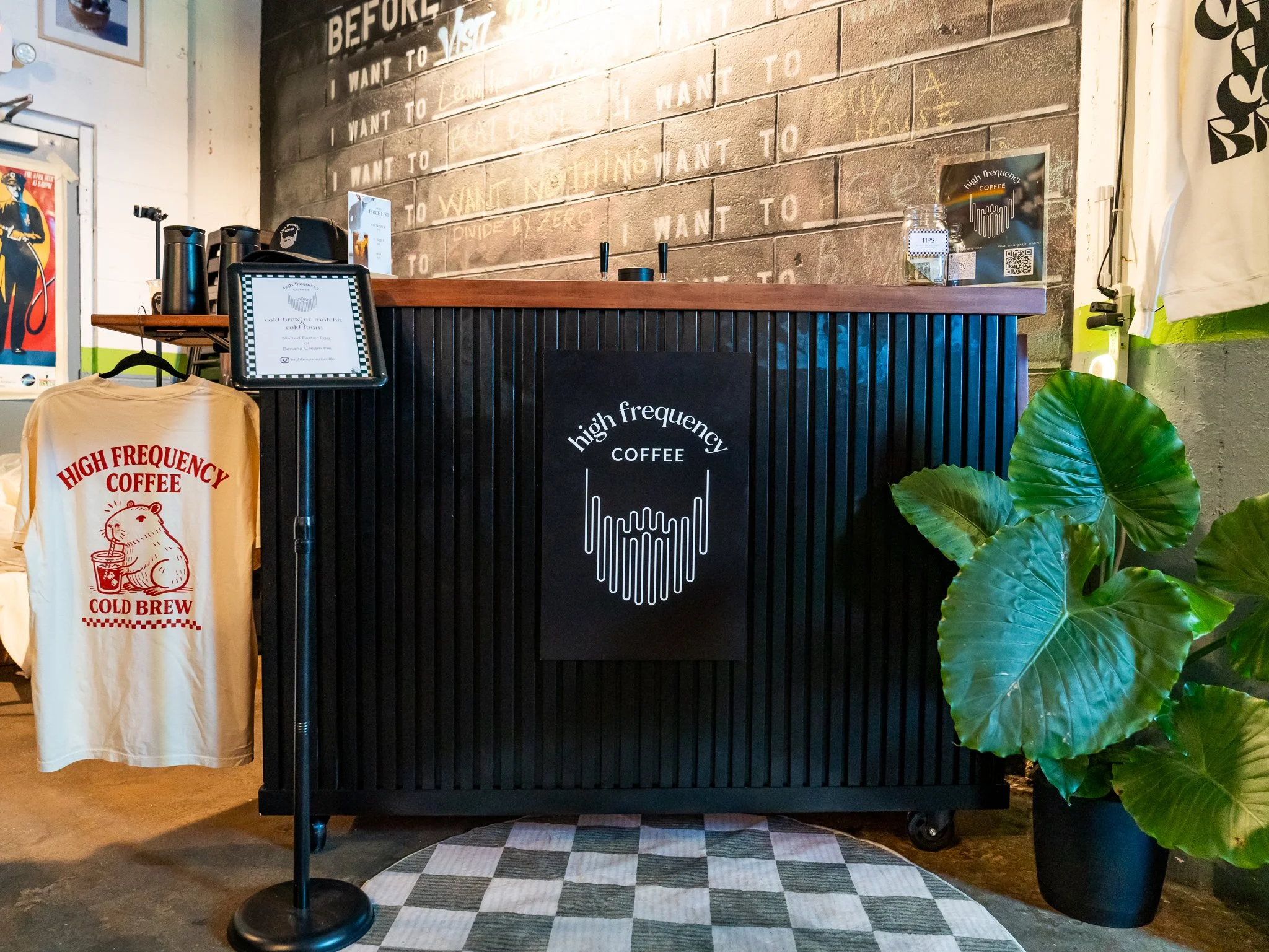 A coffee catering cart is on display, with tasteful items around it, such as a plant and custom merchandise.