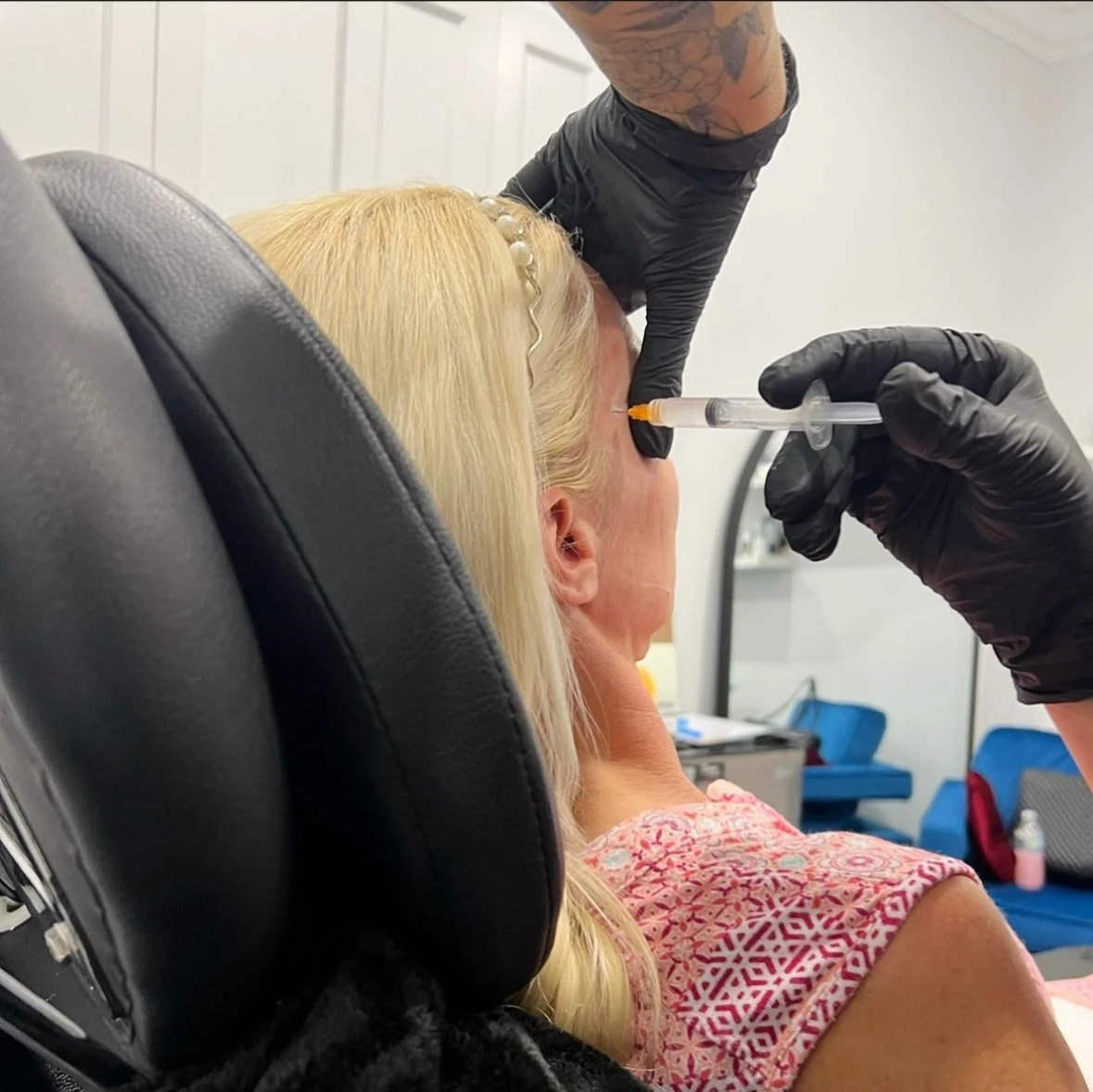 Person receiving a cosmetic injection in a clinical setting