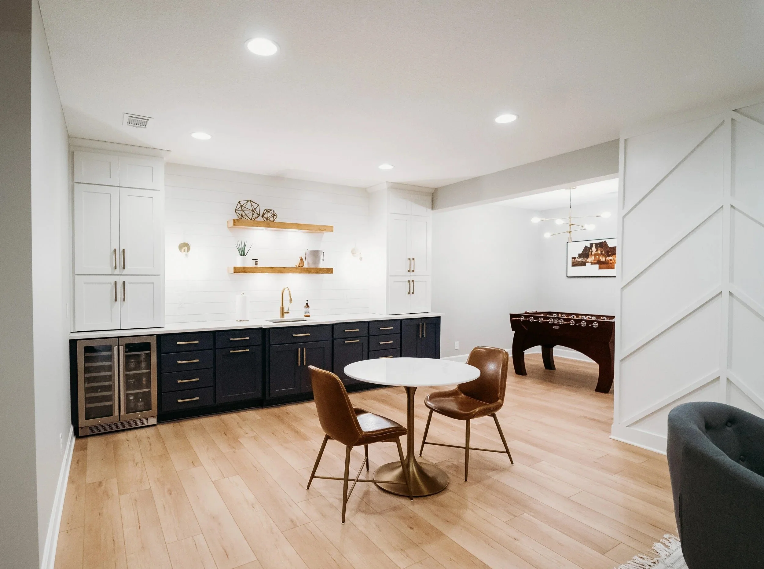 Two-tone basement bar and connected game area in an Overland Park basement finish.