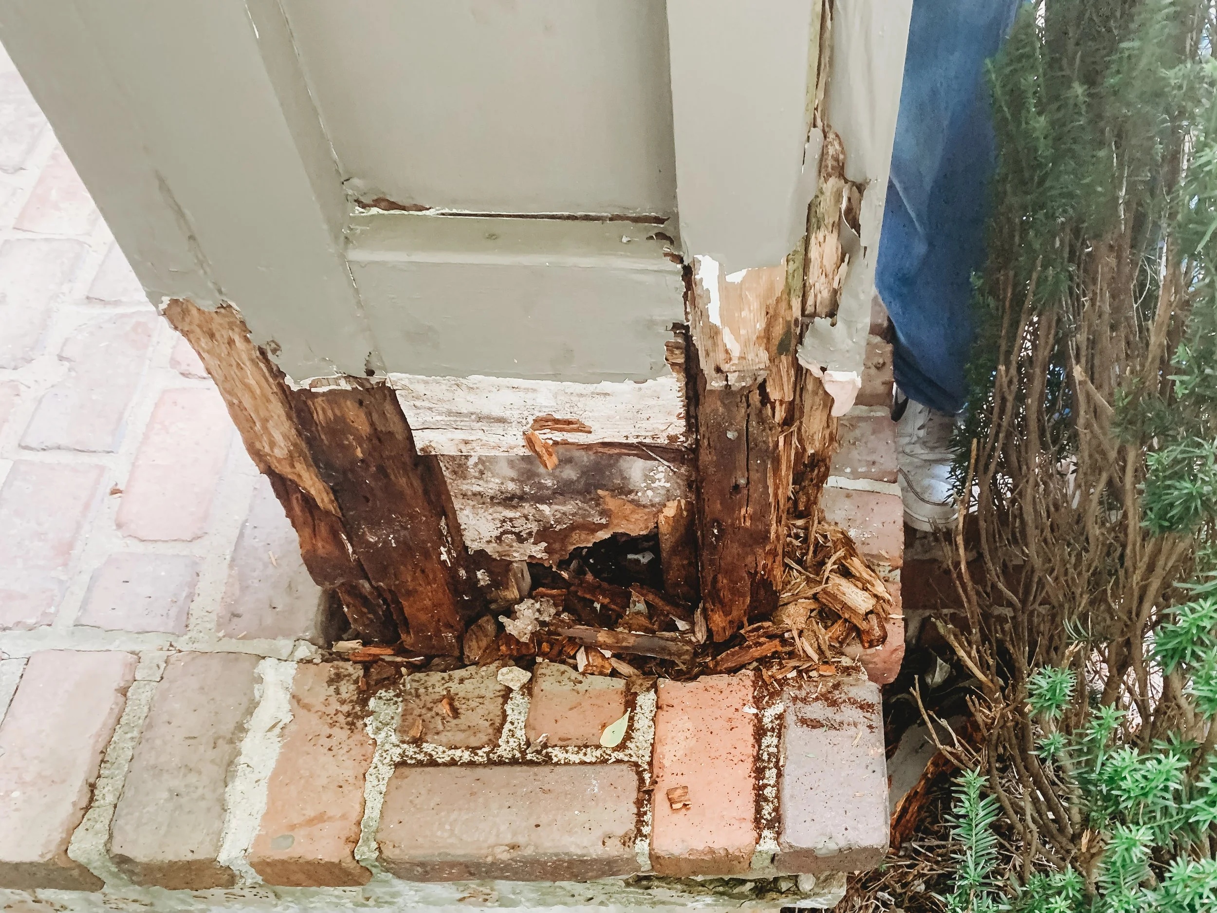 Exterior wood rot discovered at a porch column base before painting preparation.